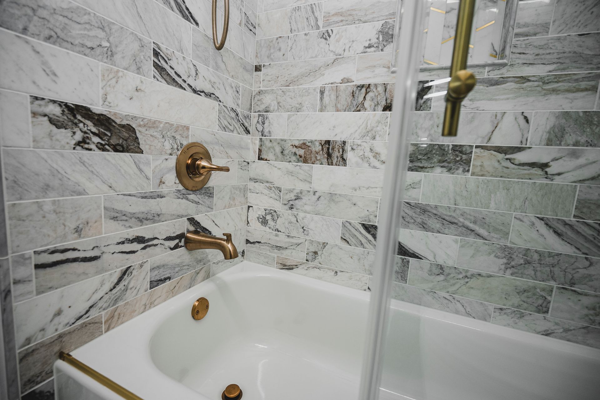 Modern walk-in shower remodel featuring custom tile and sliding glass doors.