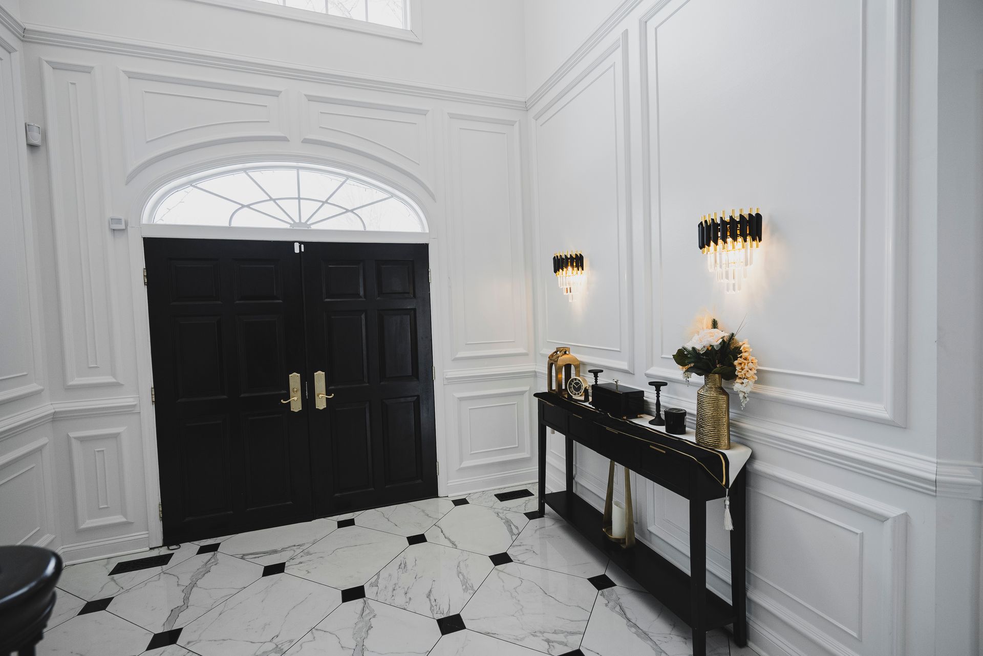 Complete foyer wall transformation with custom wood paneling and fresh white paint.