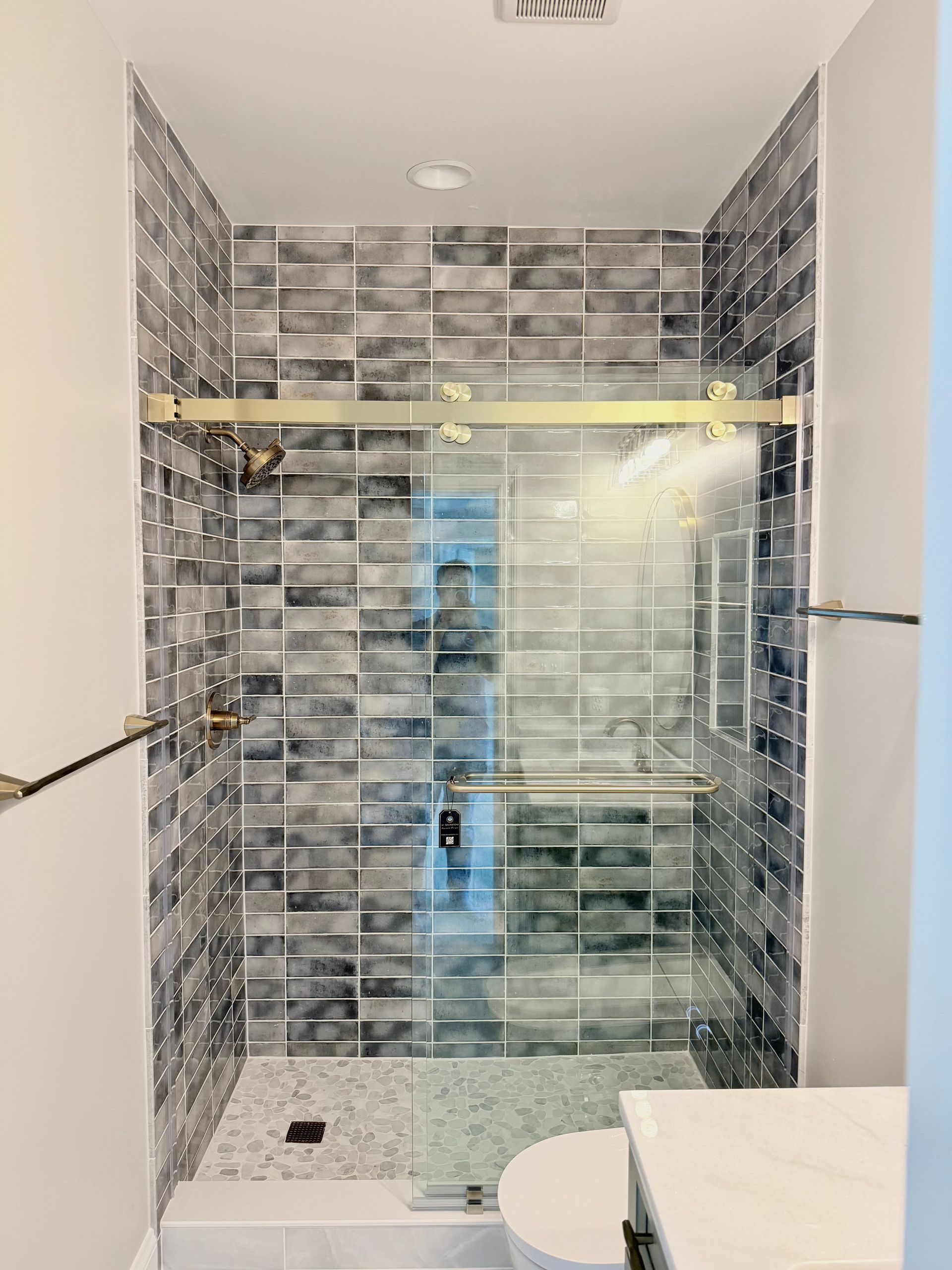 Shower detail highlighting the decorative tile and a stylish faucet.