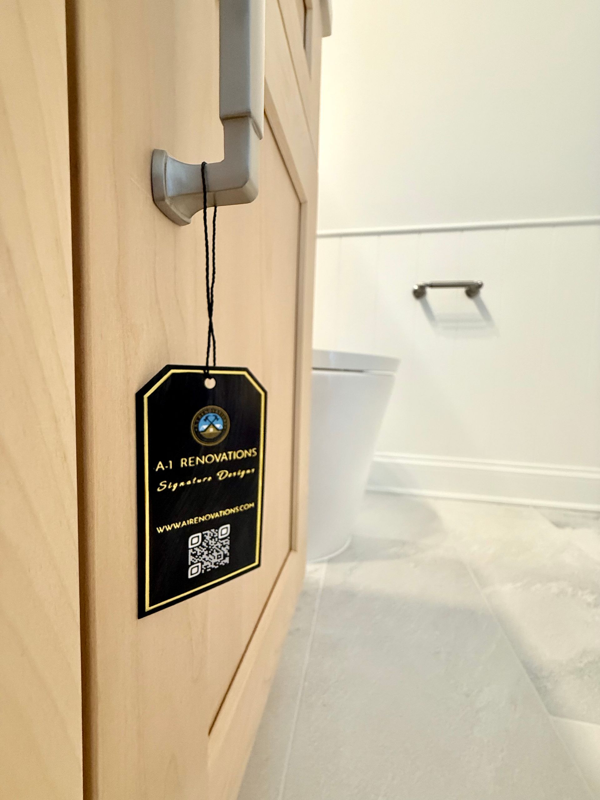 A full view of a powder room remodel showing the bold hexagonal tile accent wall, a natural wood vanity, and a new smart toilet.