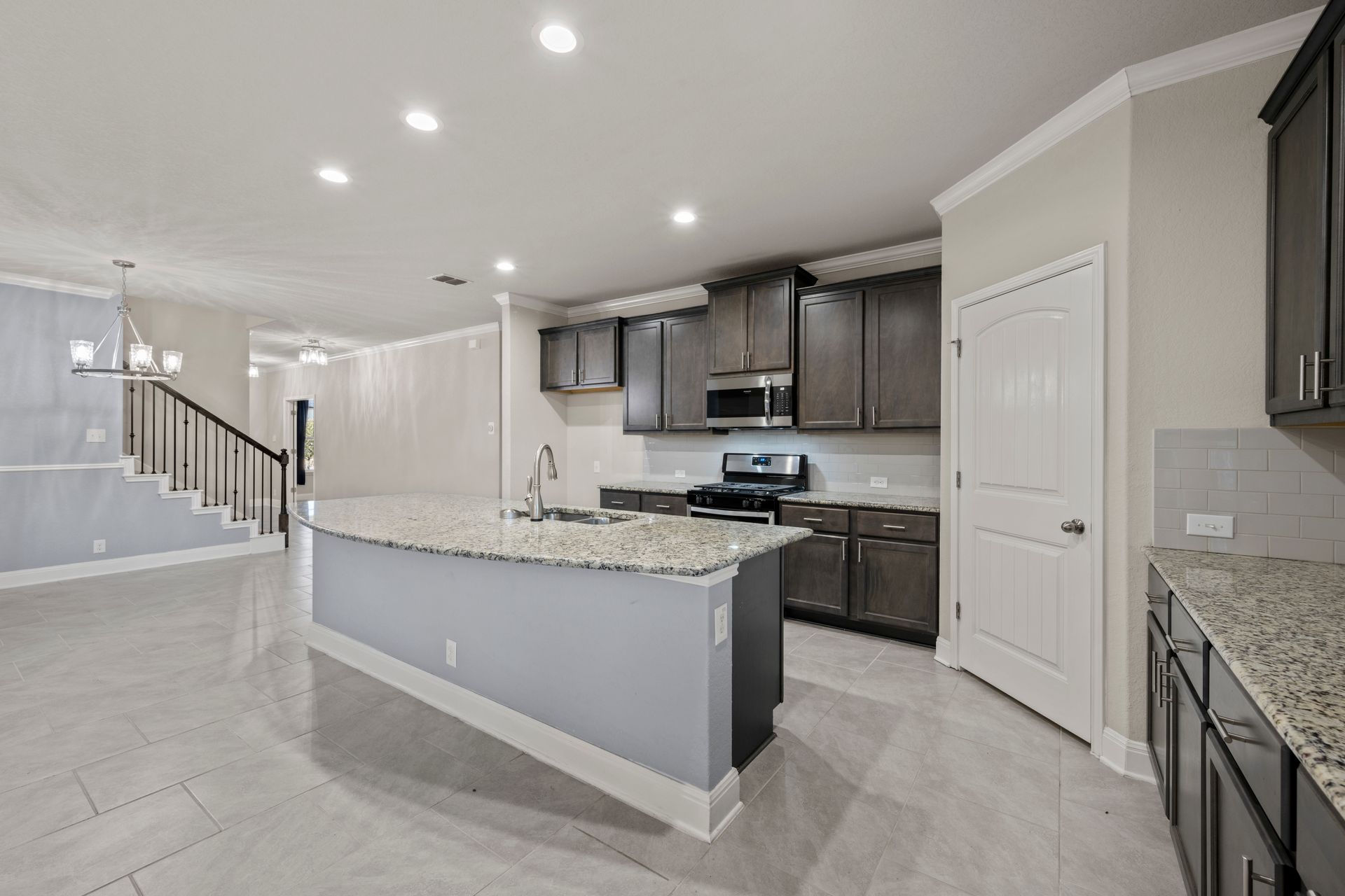 Large granite island in a dark cabinet kitchen remodel in Columbia, Maryland, featuring shaker cabinets and stainless steel appliances.