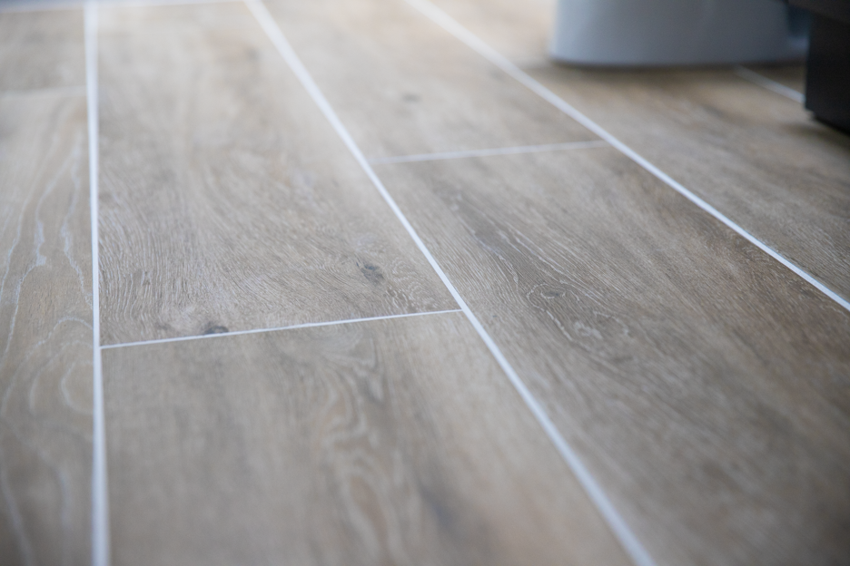 Durable flooring installation services in Ellicott City, MD, featuring wood-look porcelain tile with clean, bright grout lines.