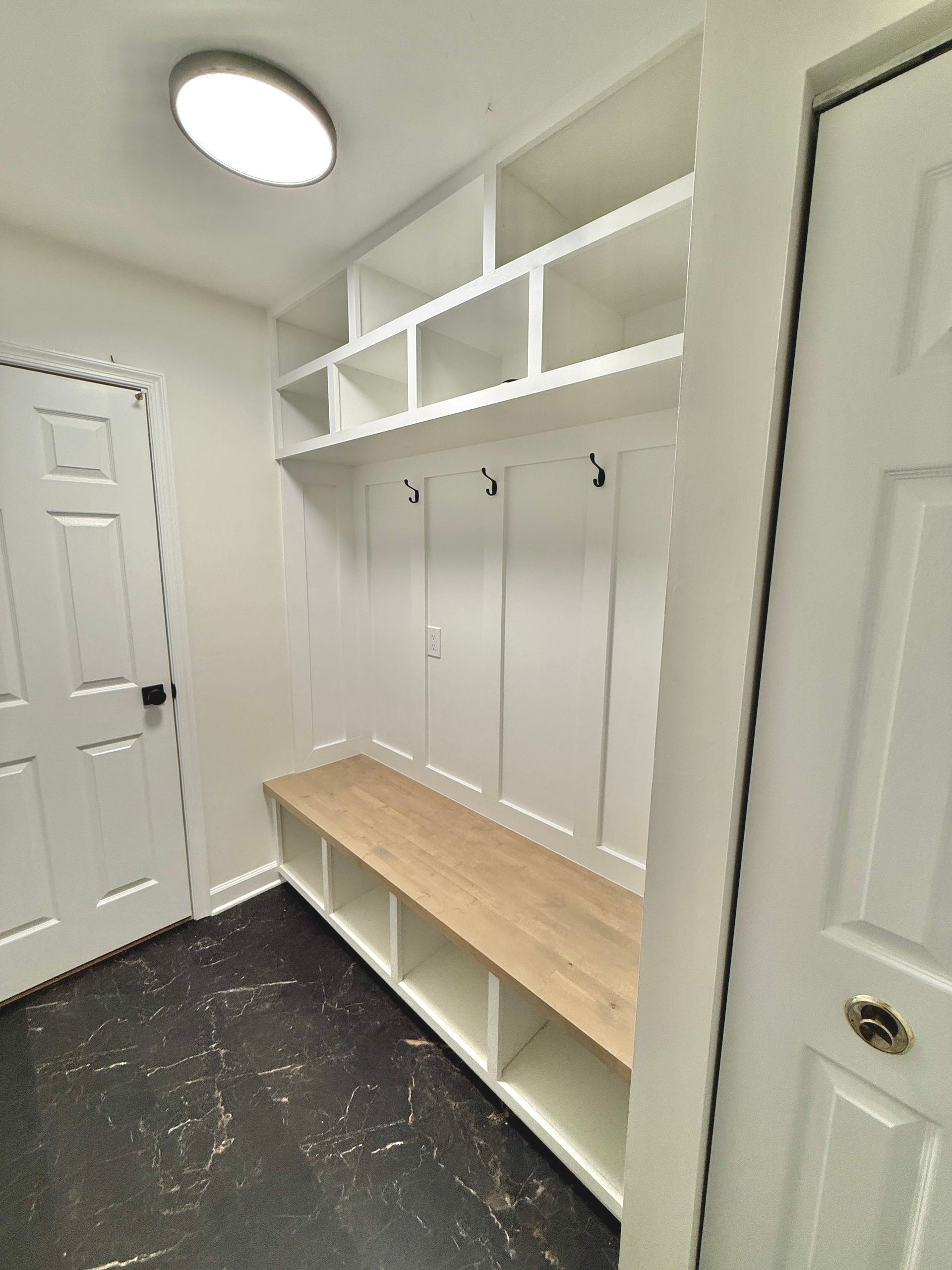 Custom board-and-batten mudroom bench and overhead cubby storage in Monkton, MD.