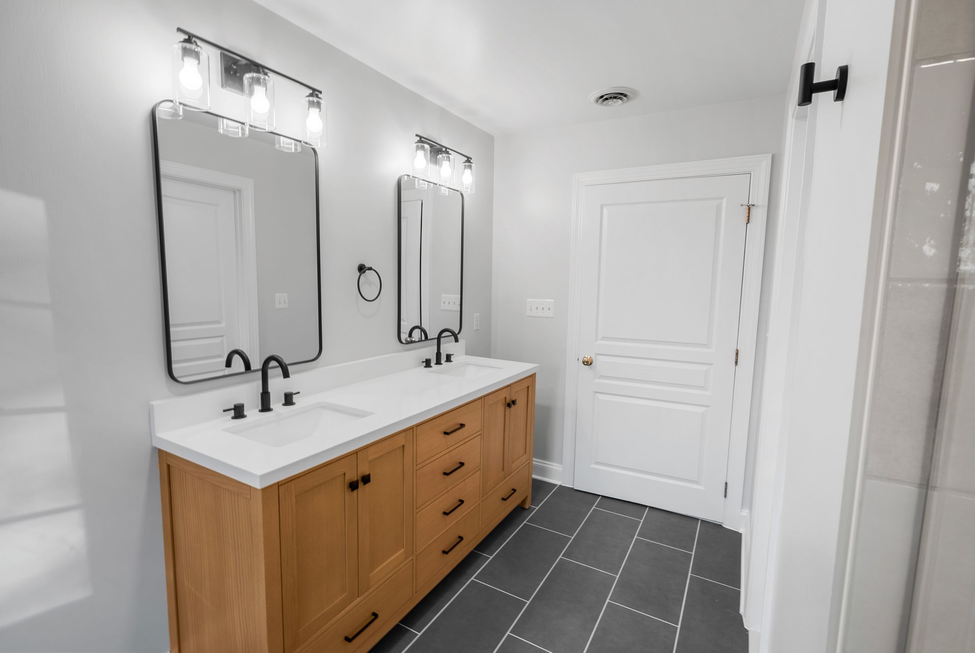 Modern rounded-rectangle vanity mirrors paired with contemporary glass-shade lighting