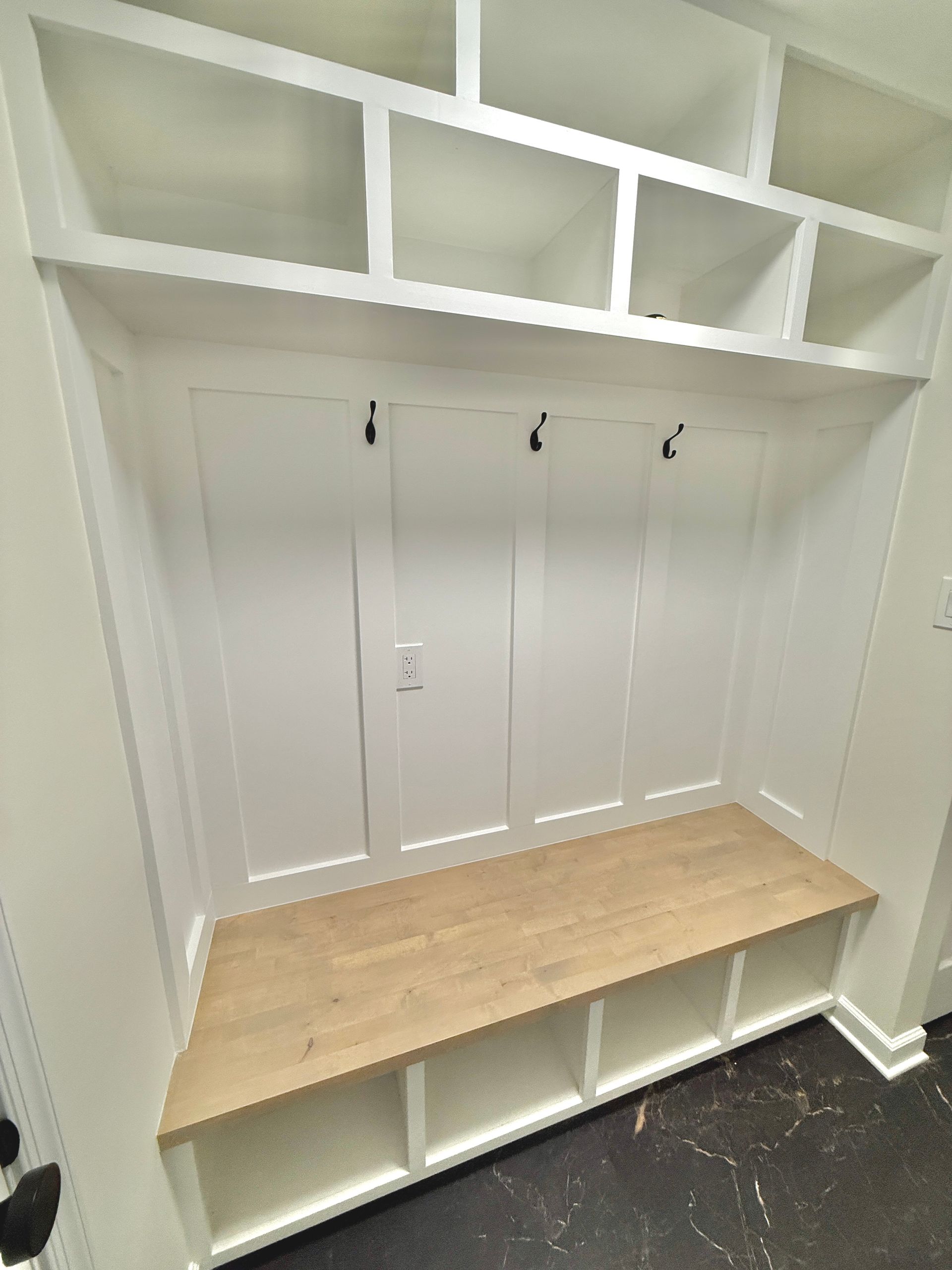 Custom board-and-batten paneling and built-in hooks for a functional and elegant mudroom entrance in Monkton.