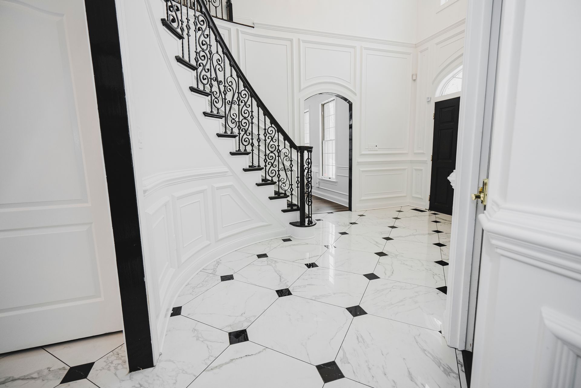 Traditional marble tile entryway floor with a timeless black and white pattern.