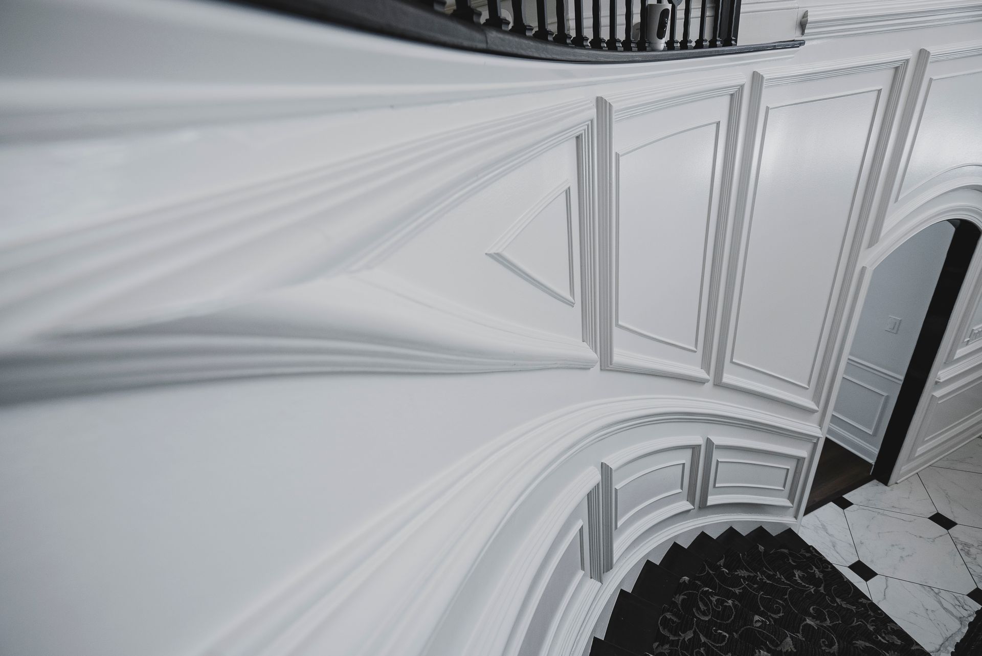 Detailed view of classical interior wall moldings and trim work in a modern foyer.
