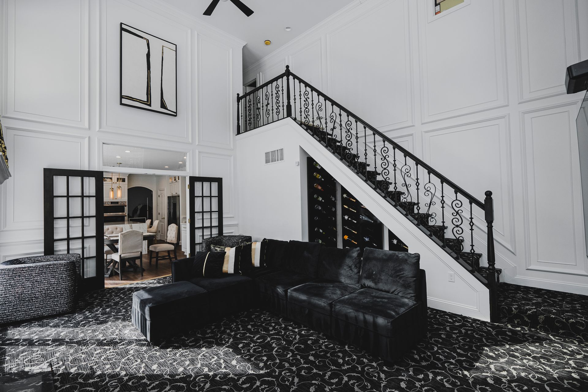 Innovative wine rack and storage cabinetry built into the space beneath a living room staircase.
