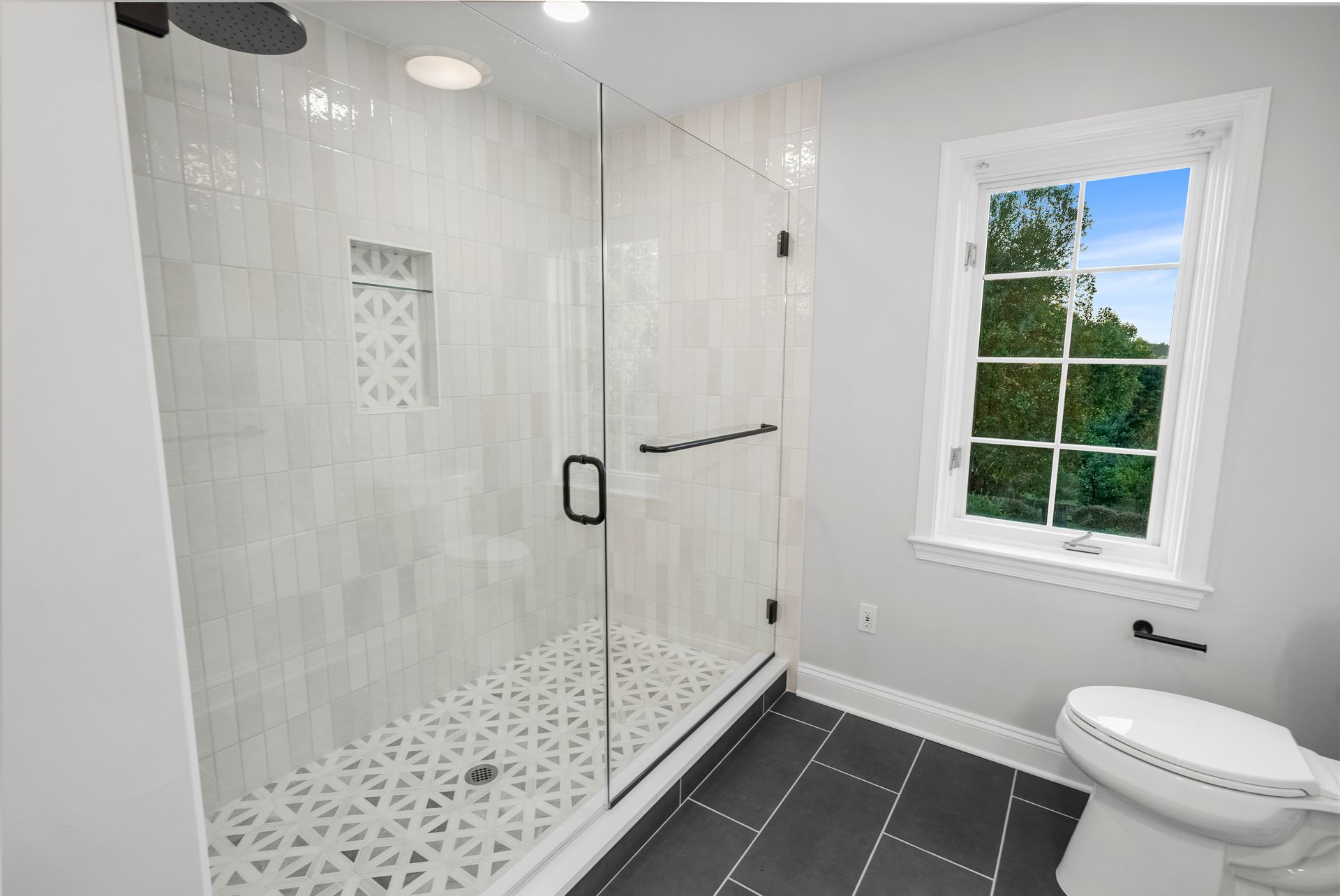 Large-format dark charcoal floor tile grounding a modern bathroom remodel