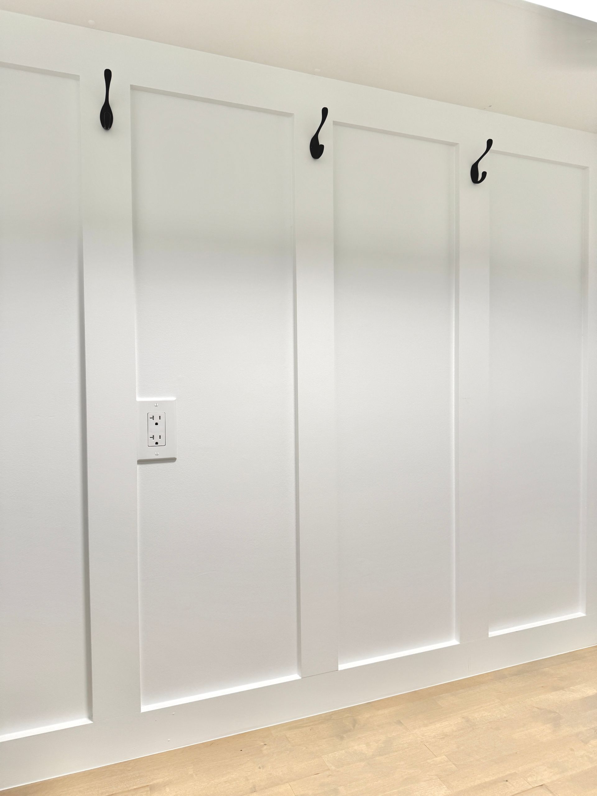 Custom mudroom bench carpentry with natural wood stain and white cubbies for shoe and basket storage.