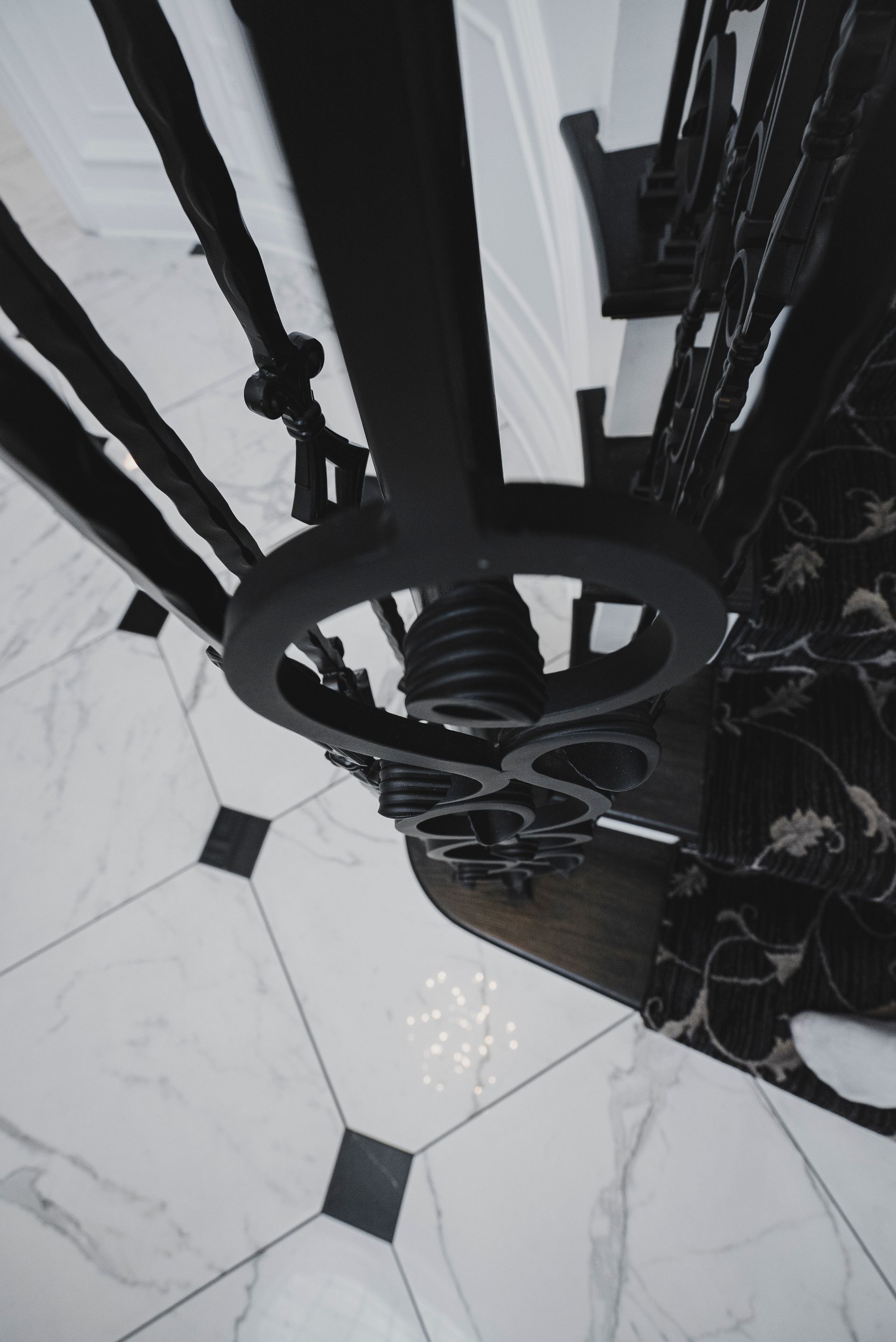 Modern black wrought iron stair railing with twisted metal spindles and a polished wood handrail.