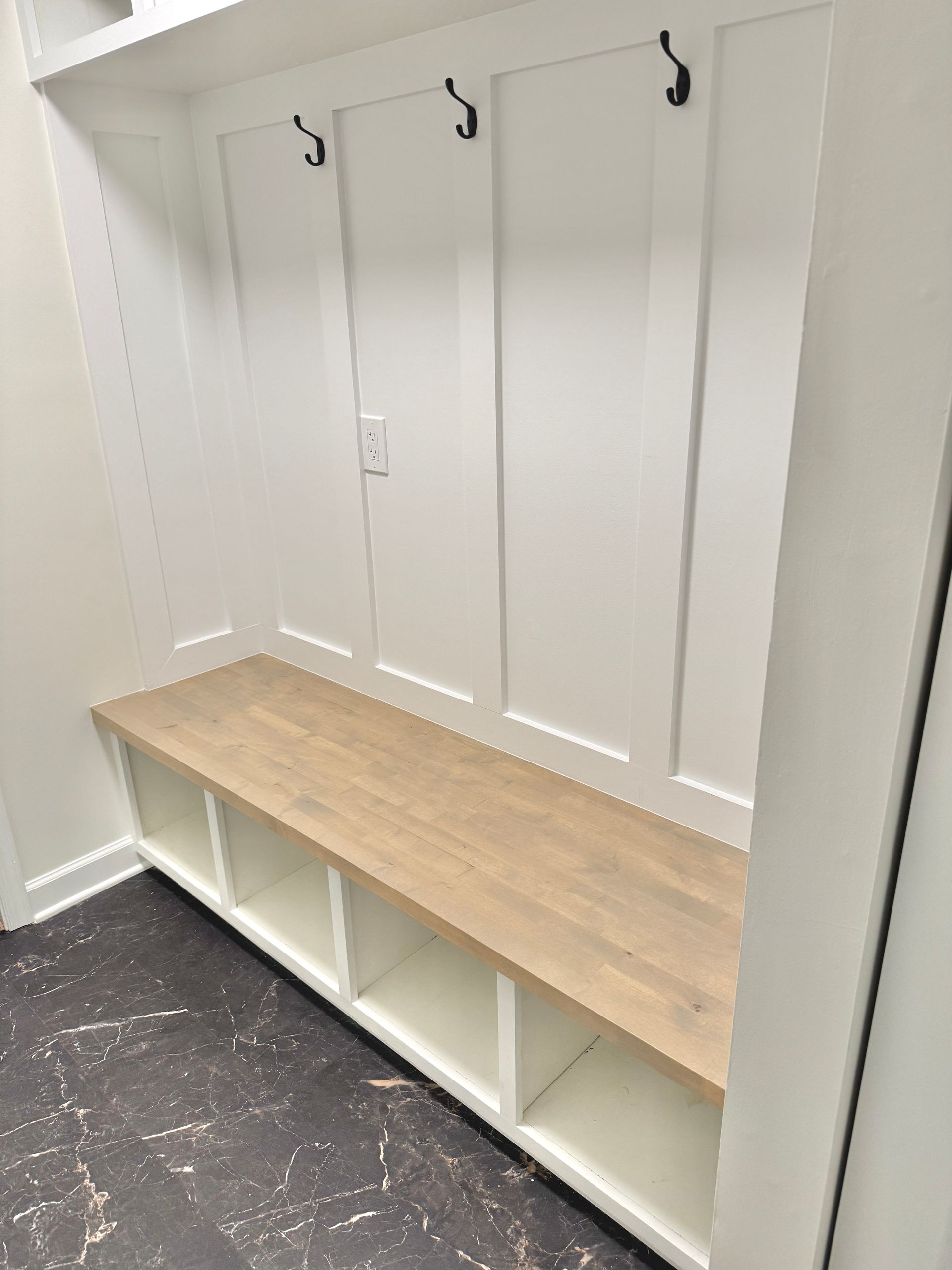 Monkton custom carpentry: built-in mudroom bench corner with white board-and-batten and cubby storage.