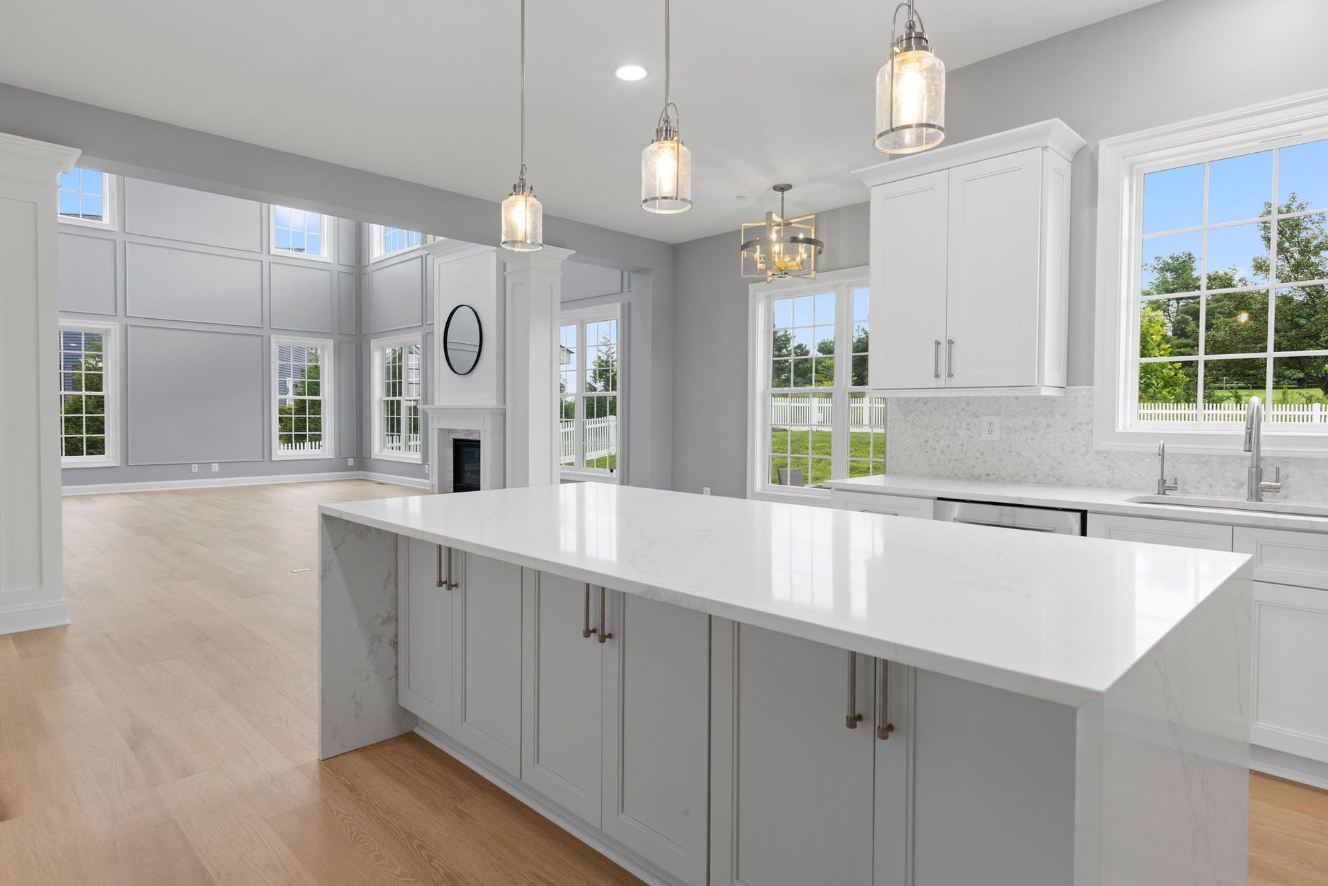 Custom kitchen island with waterfall quartz countertop installed in a structurally opened living space.