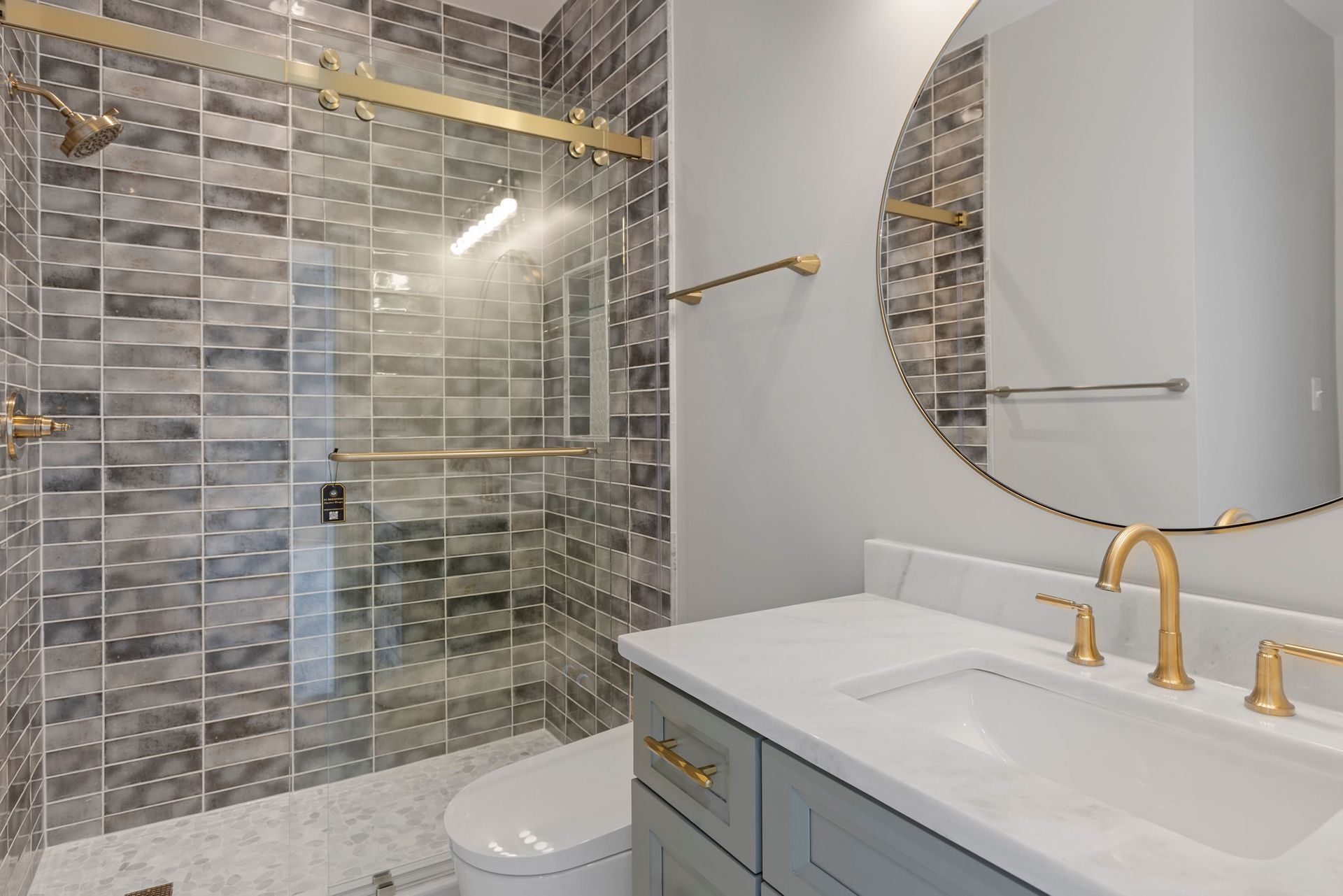Walk-in shower with a frameless glass door and custom tile work.