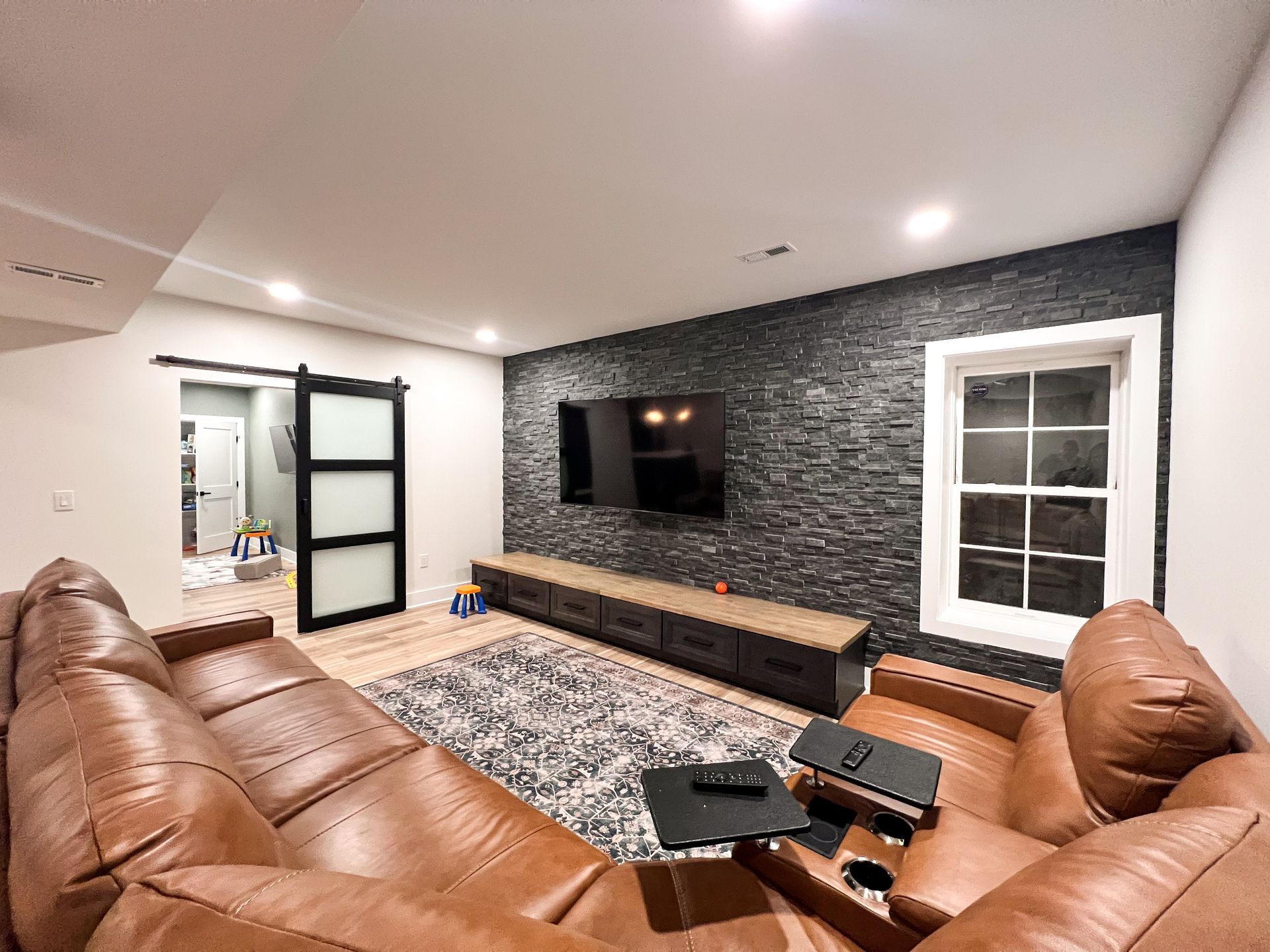 Full-service basement renovation highlighting professional drywall, lighting, and flooring installation.