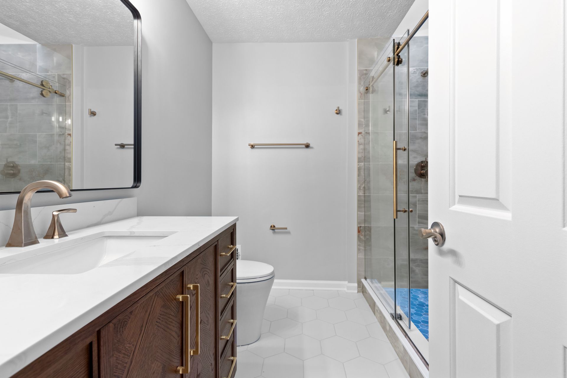 Complete bathroom transformation including new flooring, vanity, and glass shower enclosure.