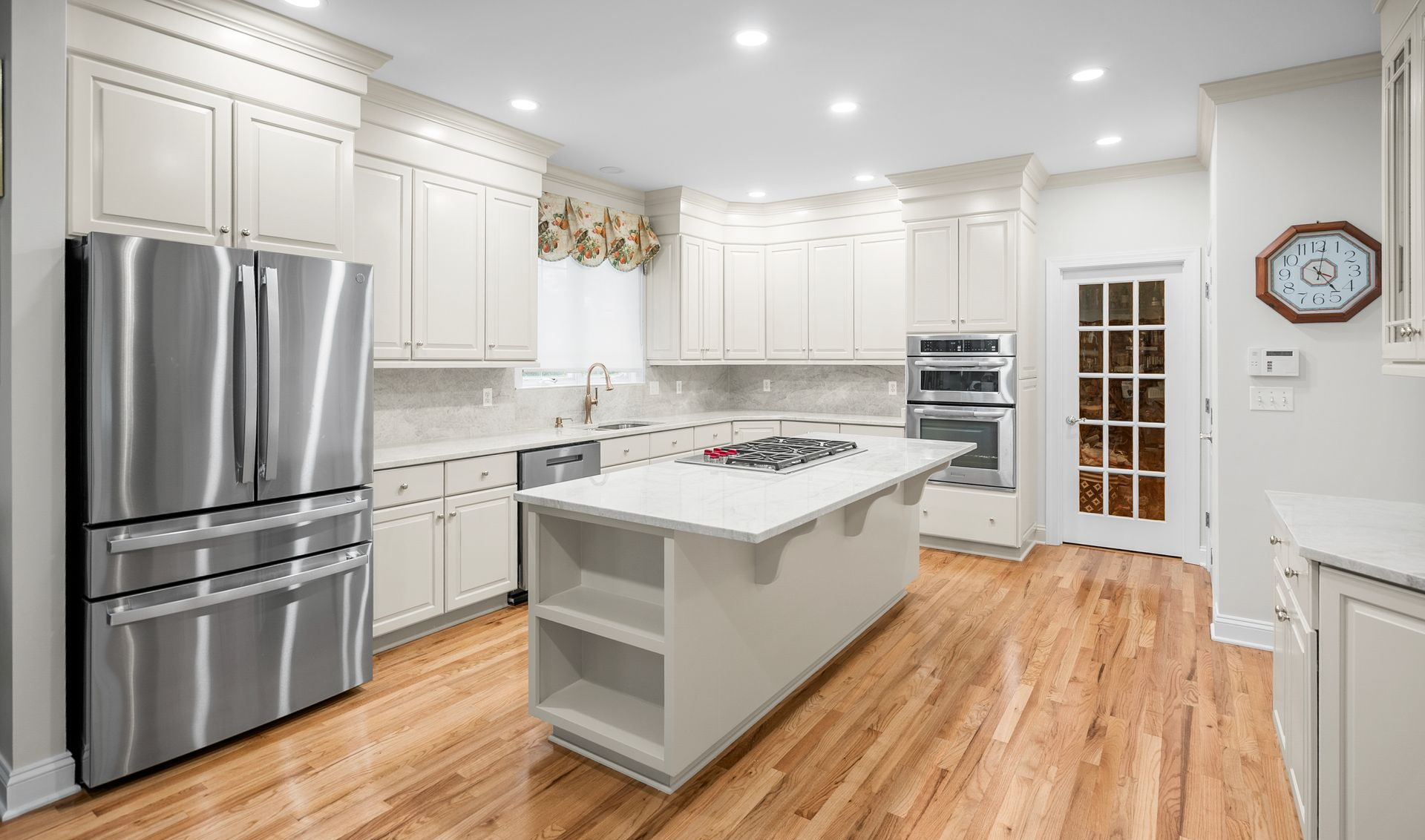 Seamless transition of light stone countertops meeting custom off-white cabinetry