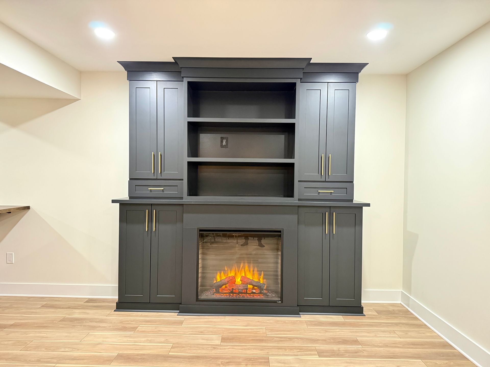 Modern basement layout with fireplace focal point and social seating.