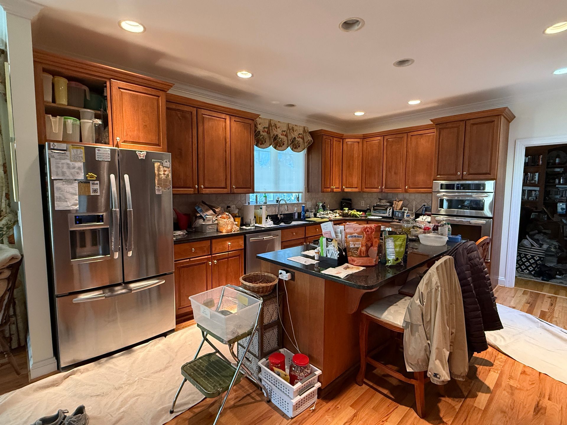 Dated kitchen before renovation featuring original warm cherry cabinets, dark granite countertops, and space above upper cabinets
