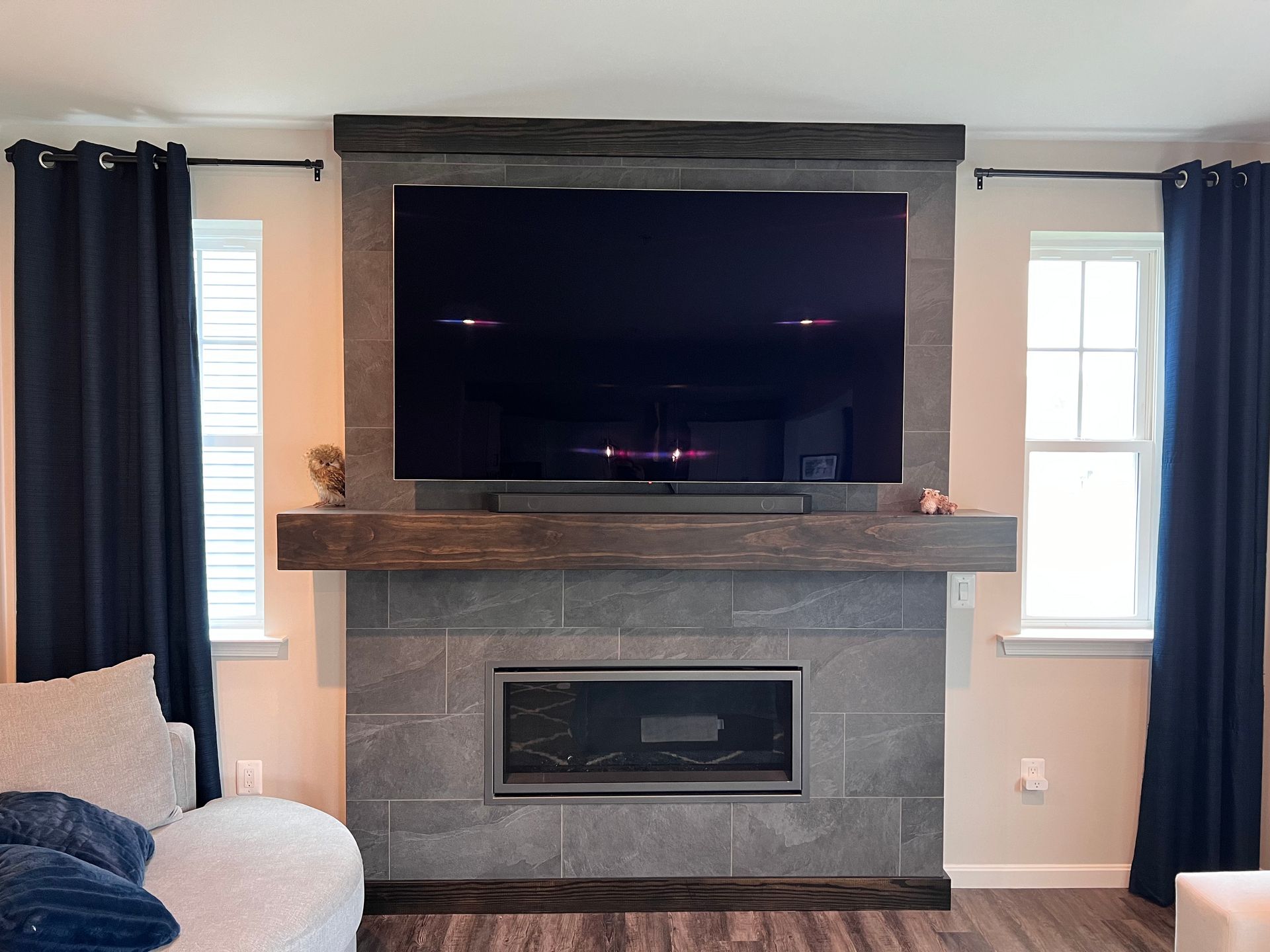 Custom-built fireplace surround with a mantel and TV in Fallston home.