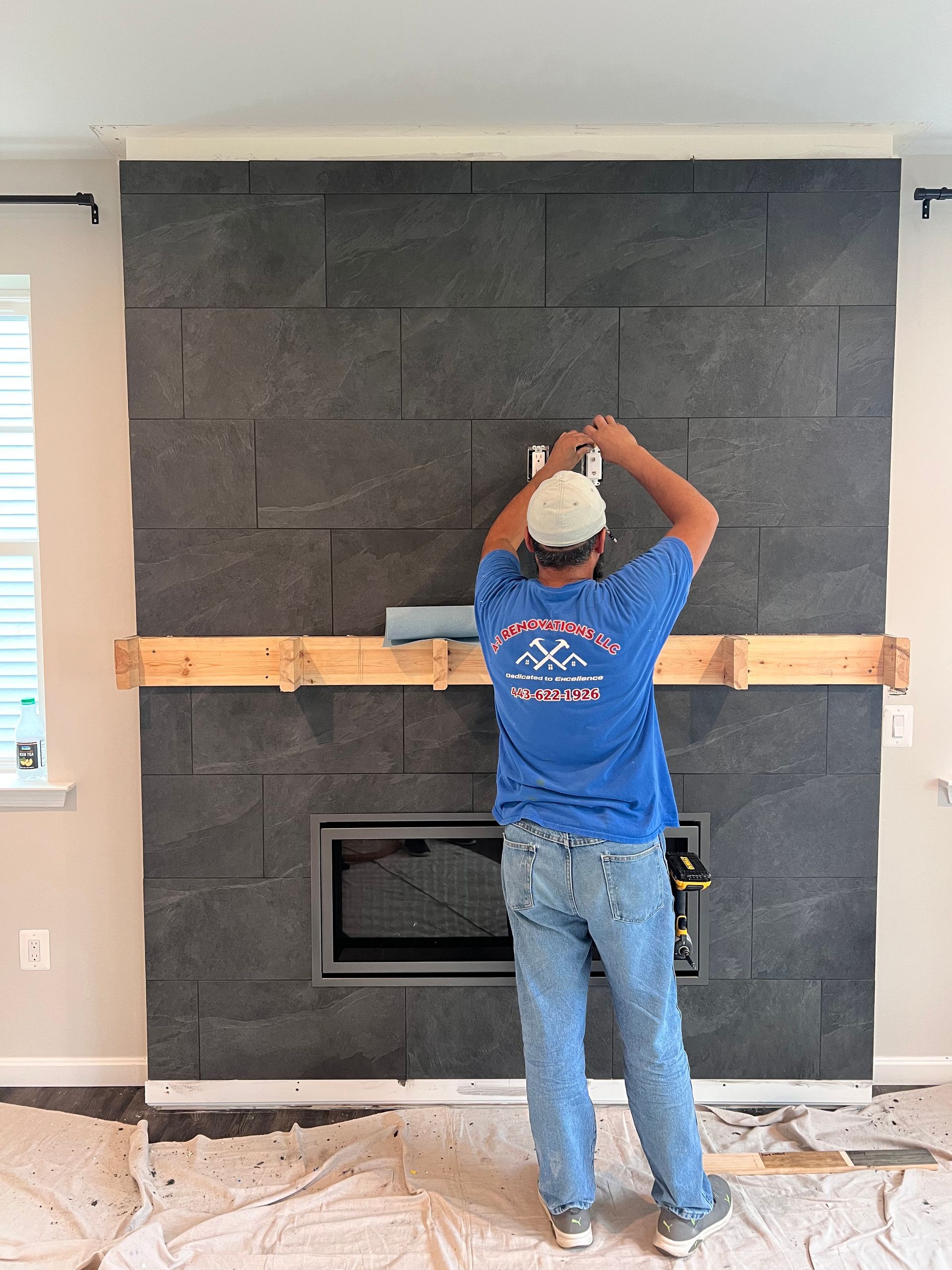 A carpenter working on a custom fireplace surround, with the mantel installation in progress in Fallston, MD