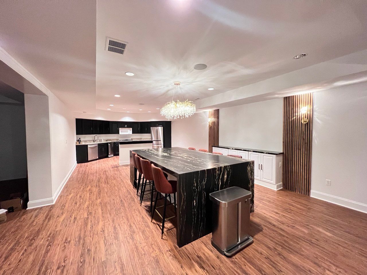 Open-concept finished basement, showcasing the combination of kitchen, dining, and li