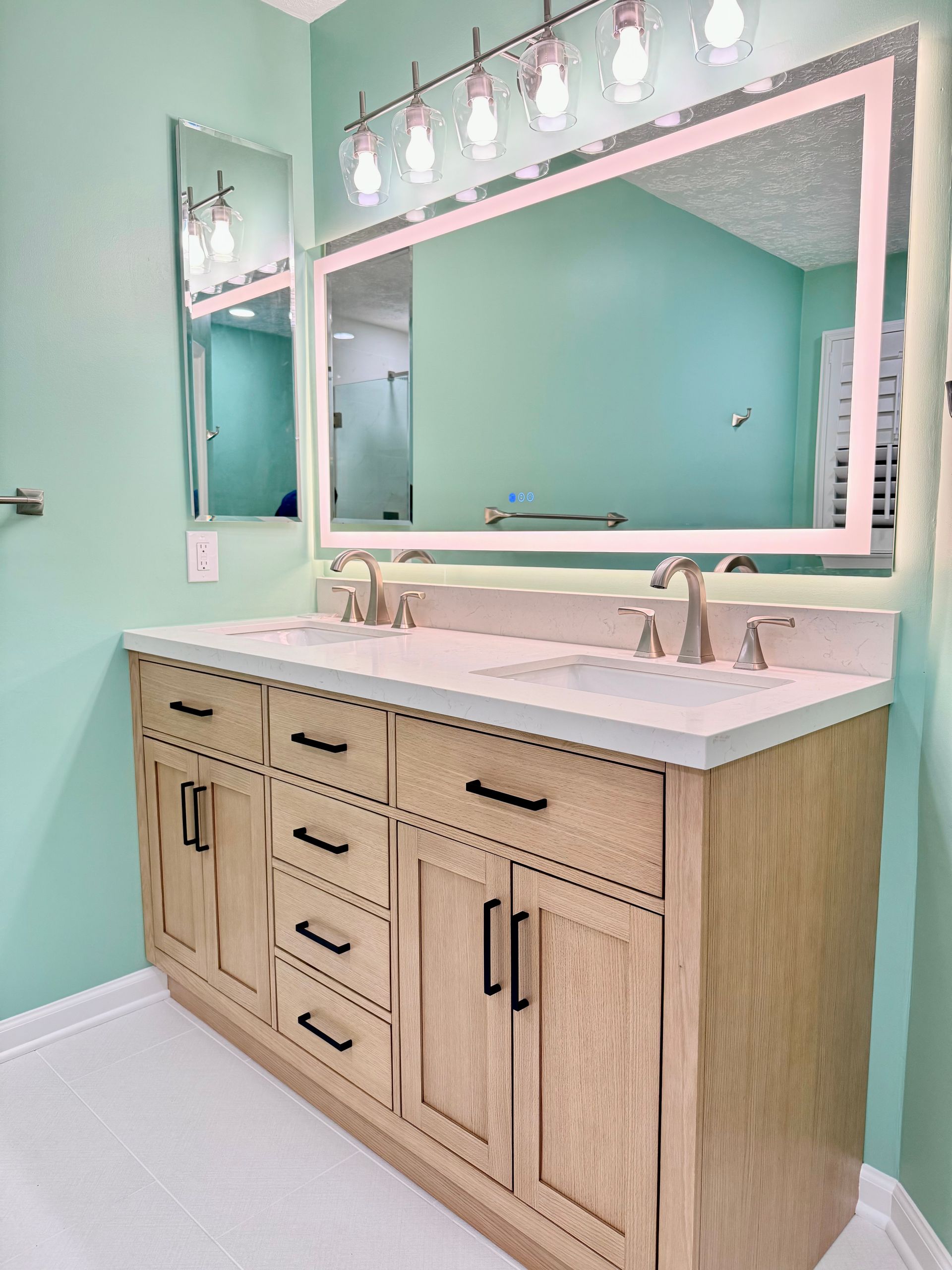 Custom wood vanity installation with quartz countertop and modern LED mirror completed for a Perry Hall bathroom.