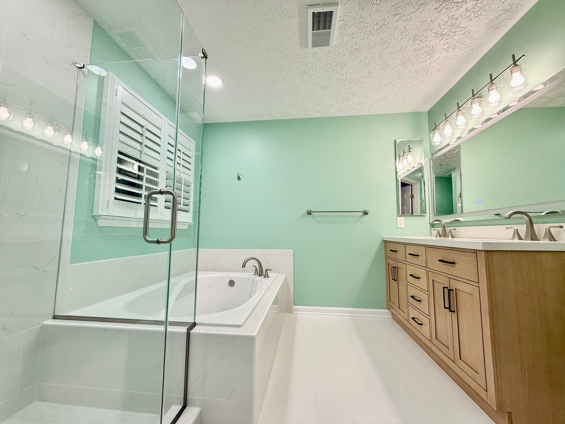Professional tile work: seamless installation of large-format tile around the rain shower head and custom wall niche.