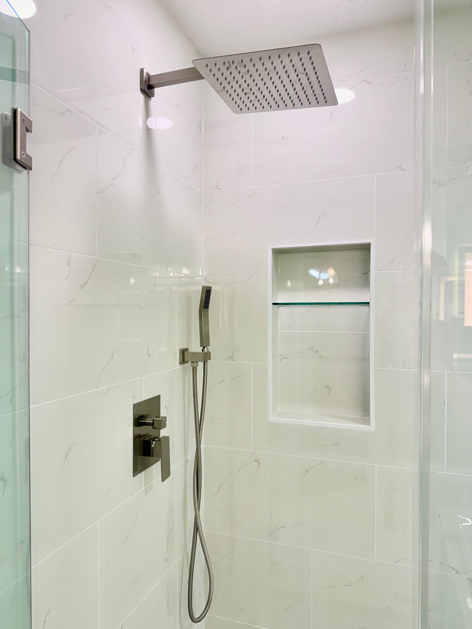 Expertly installed frameless glass shower enclosure and modern shower system by our Baltimore County remodeling team.
