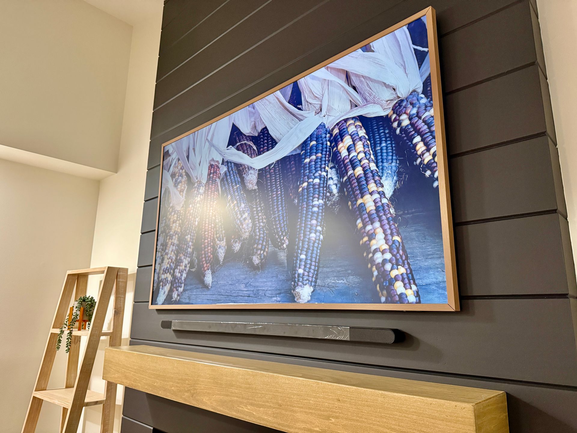 Custom carpentry: angled installation of black shiplap and floating wood mantel with integrated TV mount.