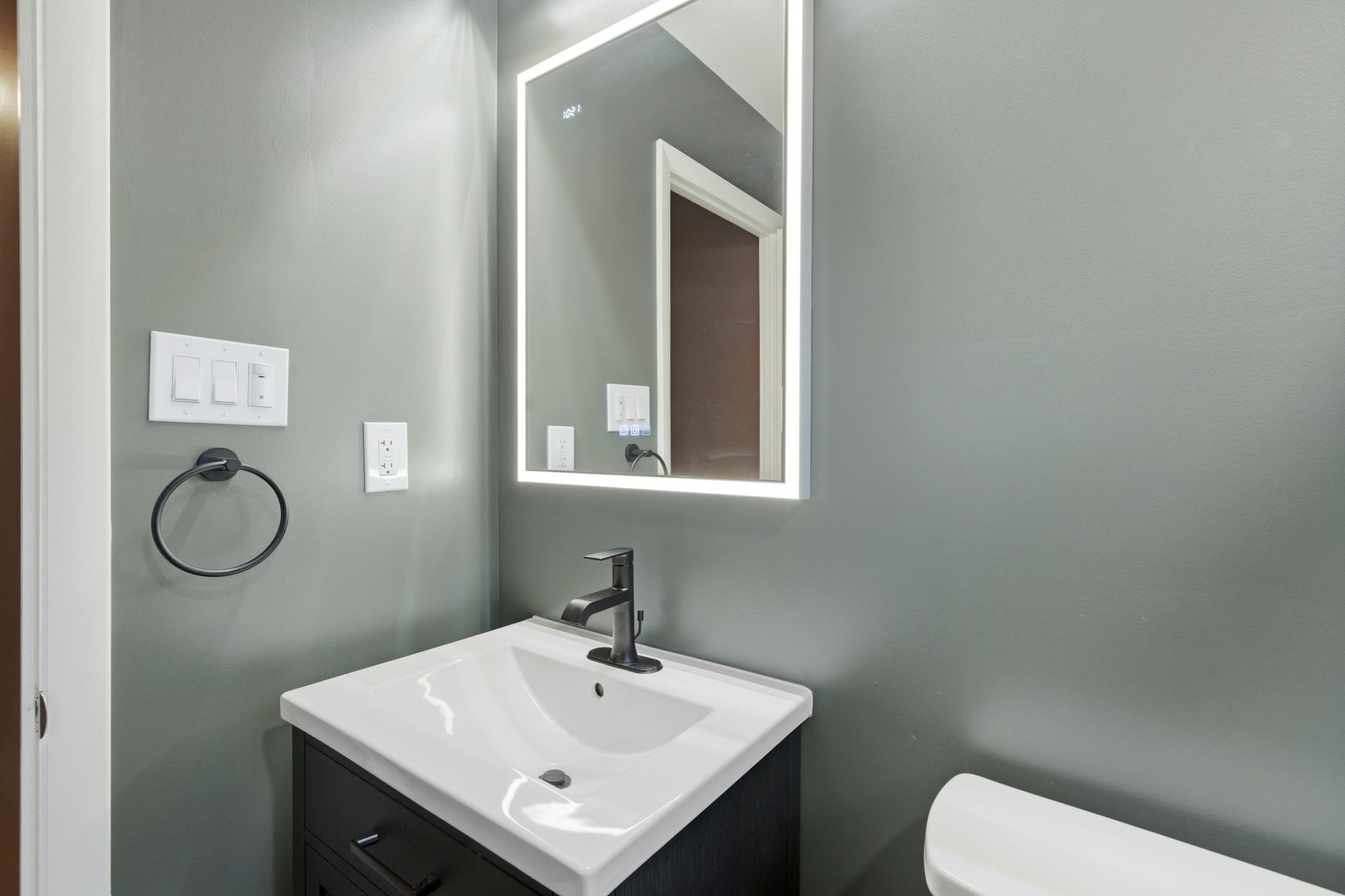 Professional installation of modern vanities and bright bathroom lighting.