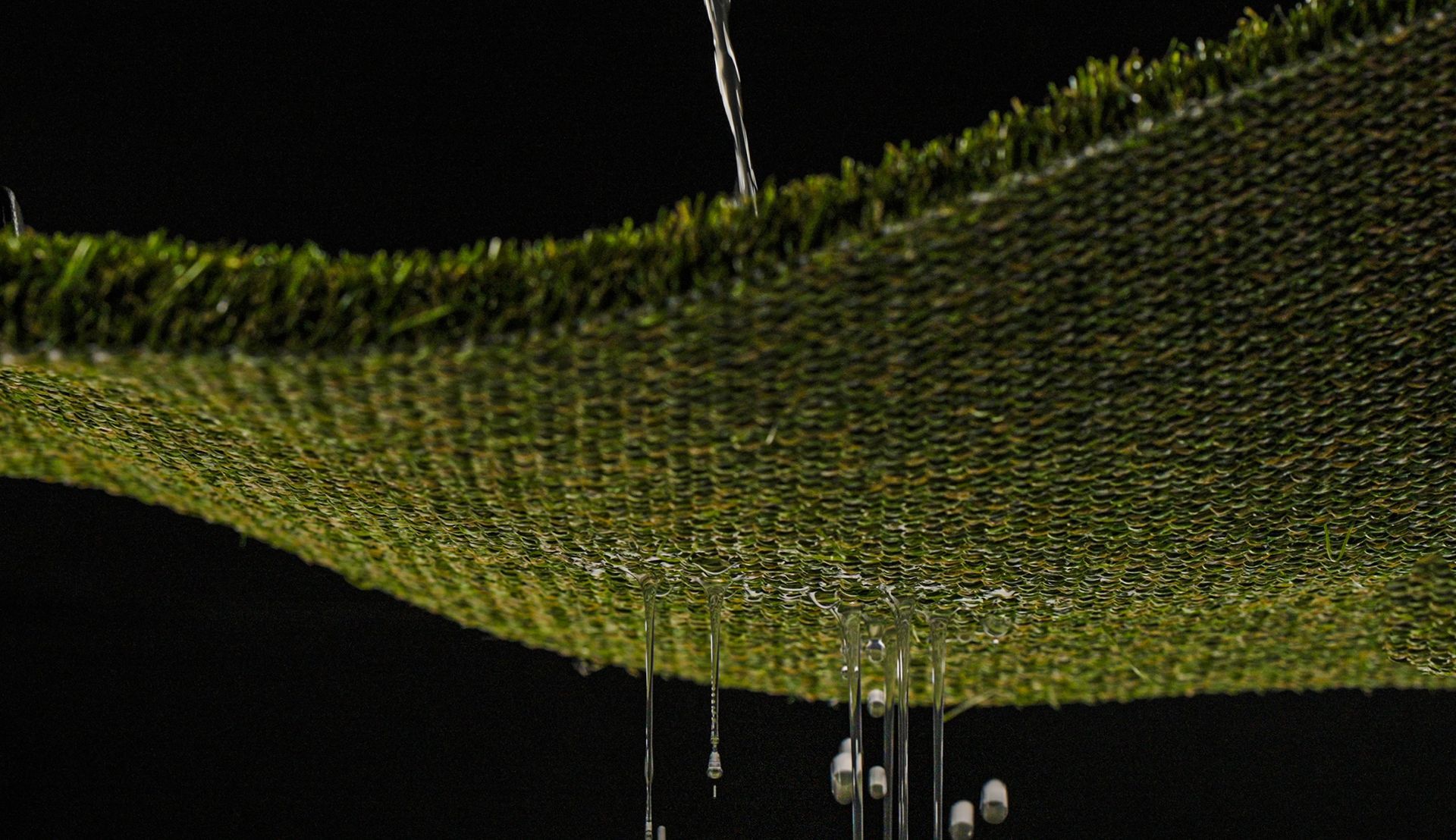 A close up of a piece of artificial grass on a white background.