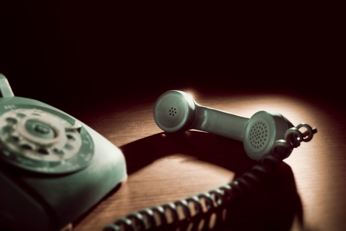 an old fashioned telephone is sitting on a wooden table .