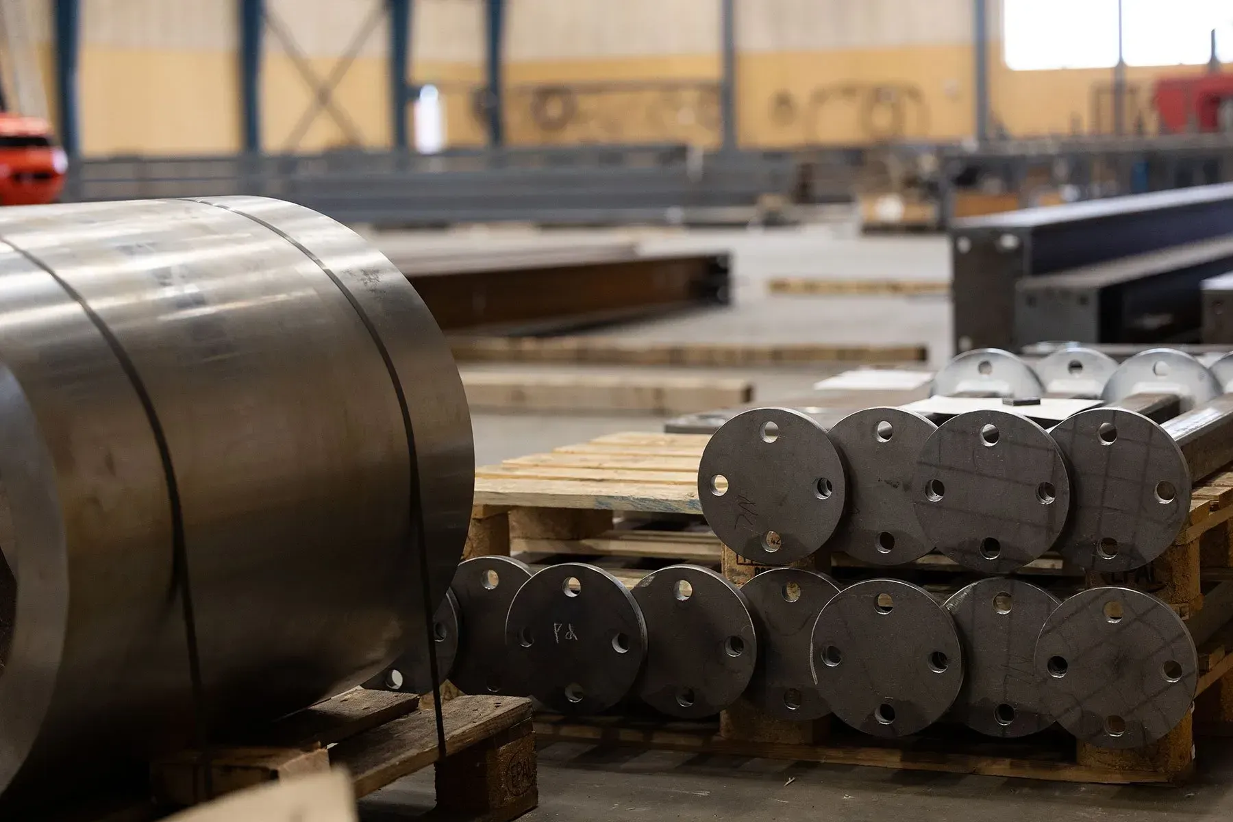 Industrielle metalspoler og stablede cylindriske dele i et lagerværksted