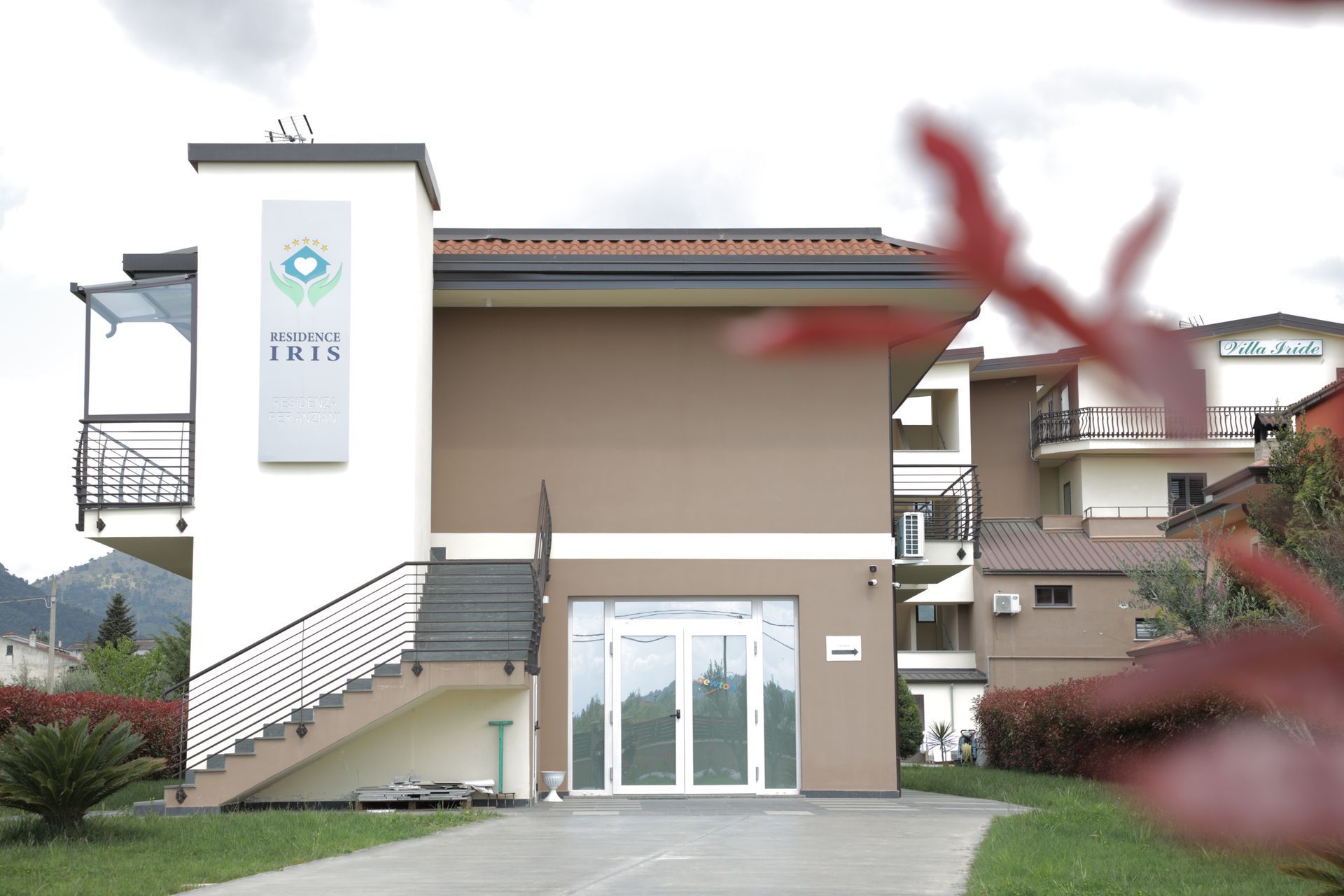 Un edificio moderno a due piani con una torre bianca che mostra il logo 