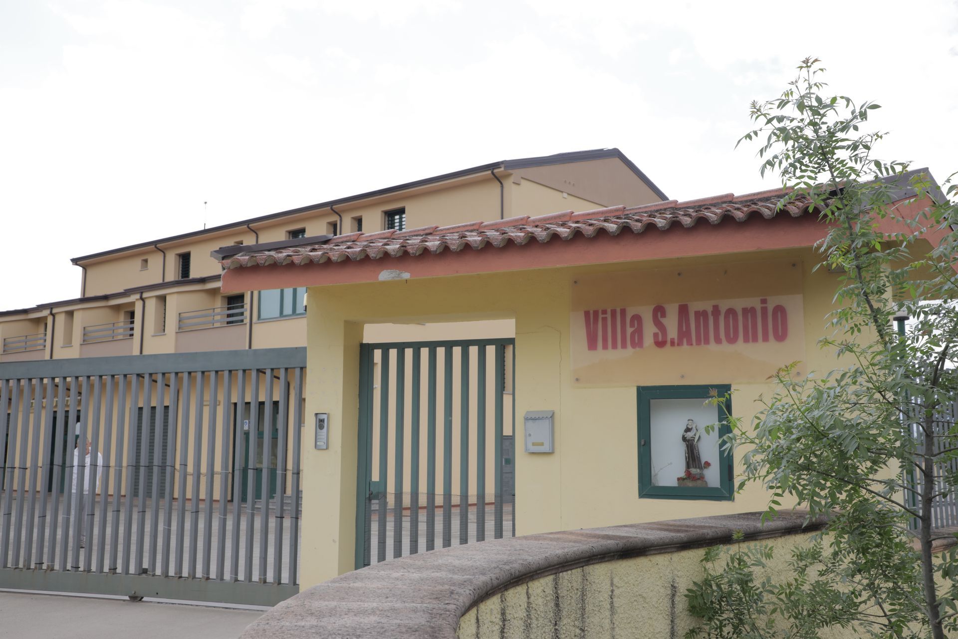 Una foto esterna di un edificio giallo con la scritta 