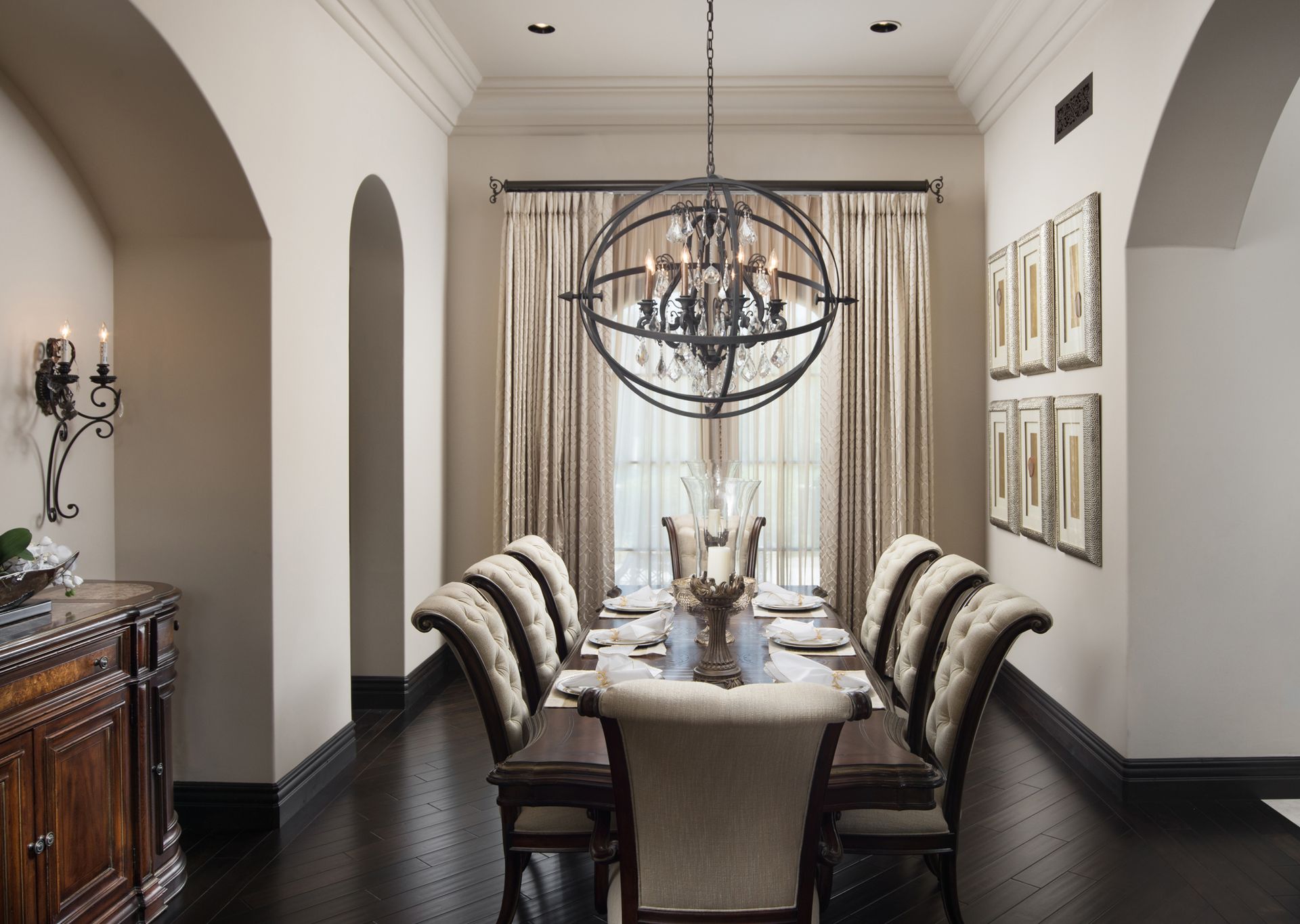 A dining room with a long table and chairs and a chandelier