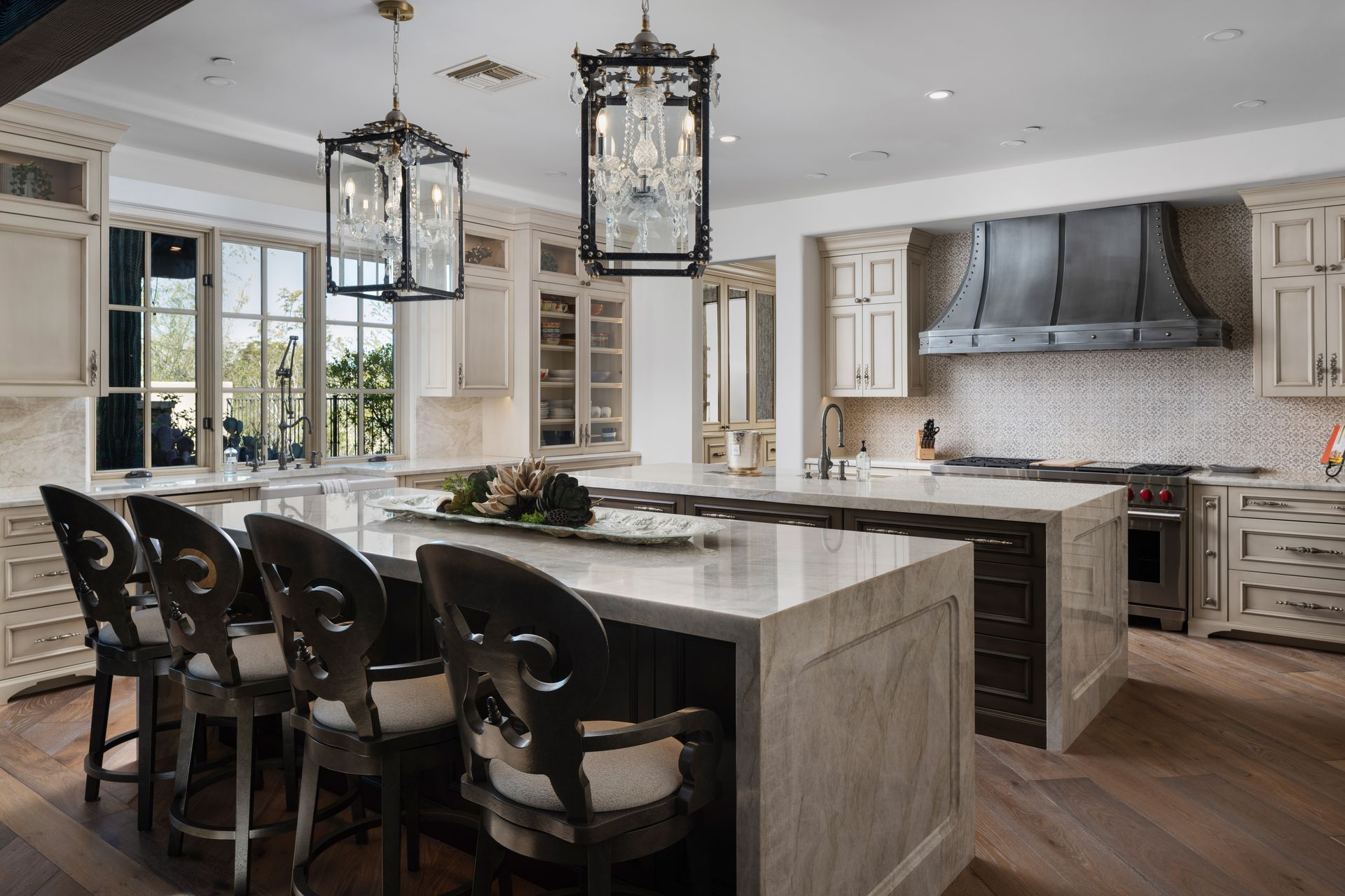 Elegant kitchen with large island, hanging lights, and custom cabinetry.