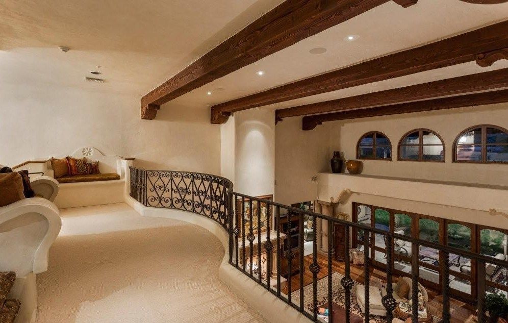 A living room with a balcony and wooden beams