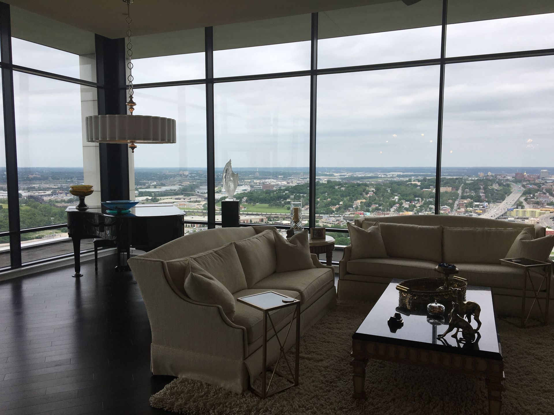 A living room with a lot of windows and a view of the city