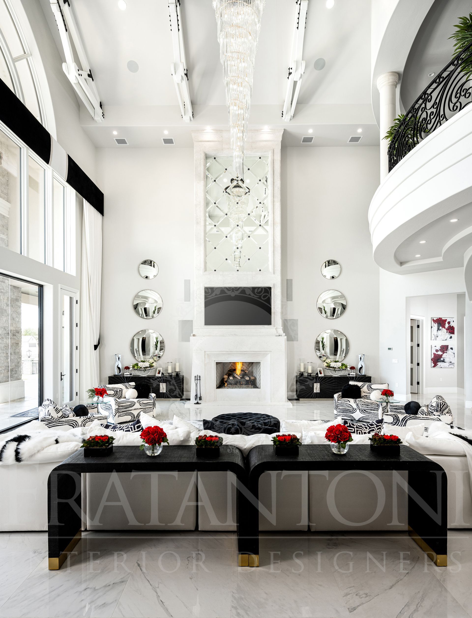 Elegant white living room with fireplace, mirrored wall detail, and two black tables with red flowers designed by Fratantoni Interior Designers in scottsdale arizona