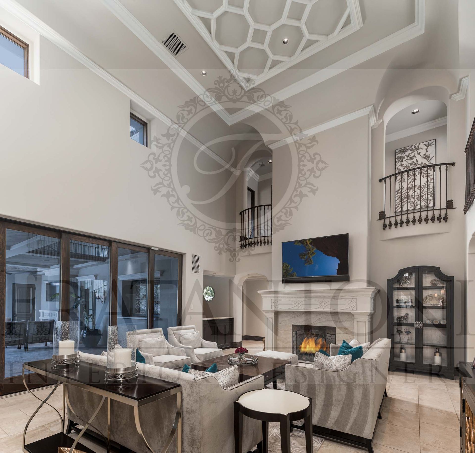 Grand living room with tall ornate ceiling, fireplace, TV, gray sofas, and large glass doors designed by fratantoni interior designers in scottsdale arizona