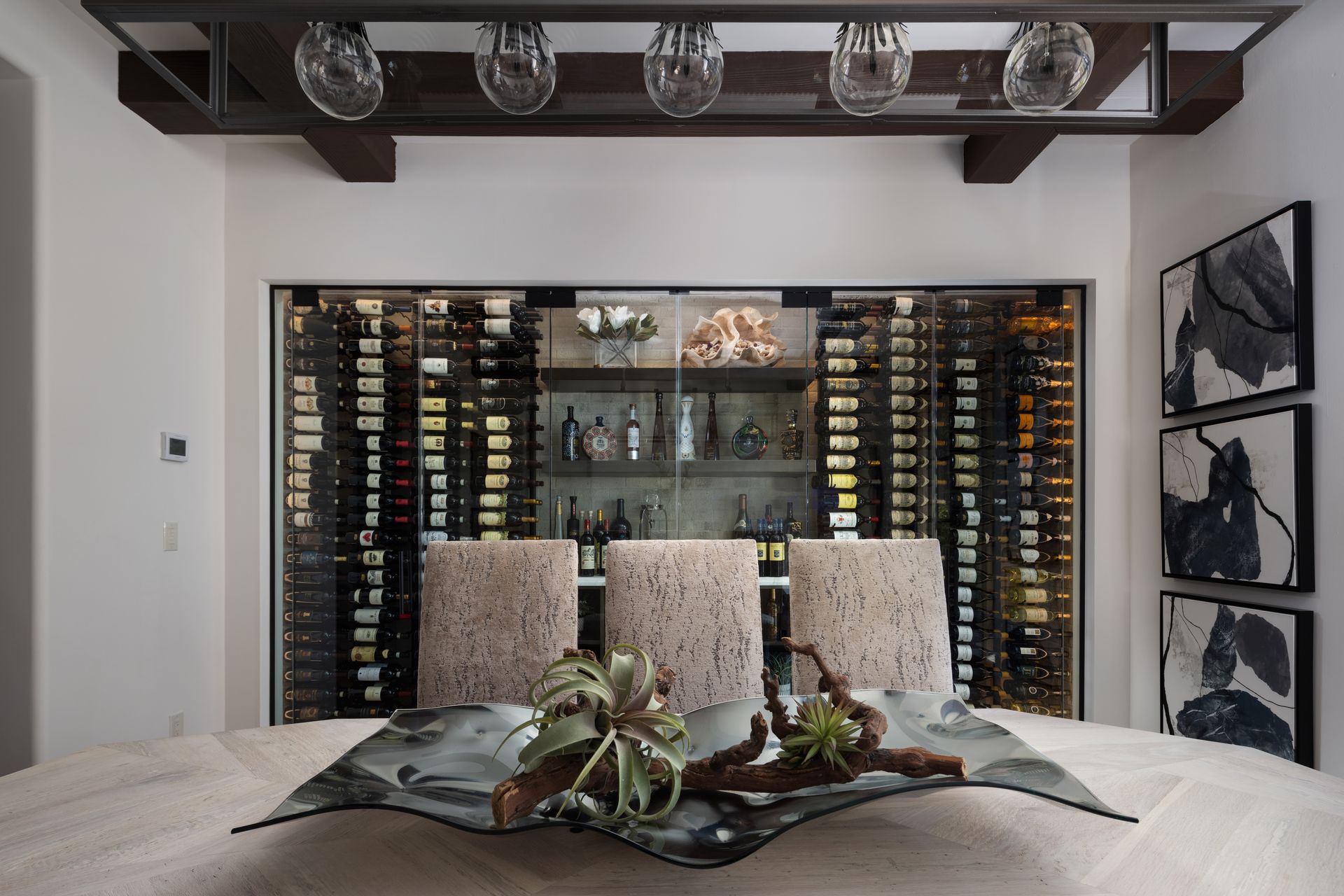 Wine cellar with bar seating, stocked wine racks, and decorative centerpiece.