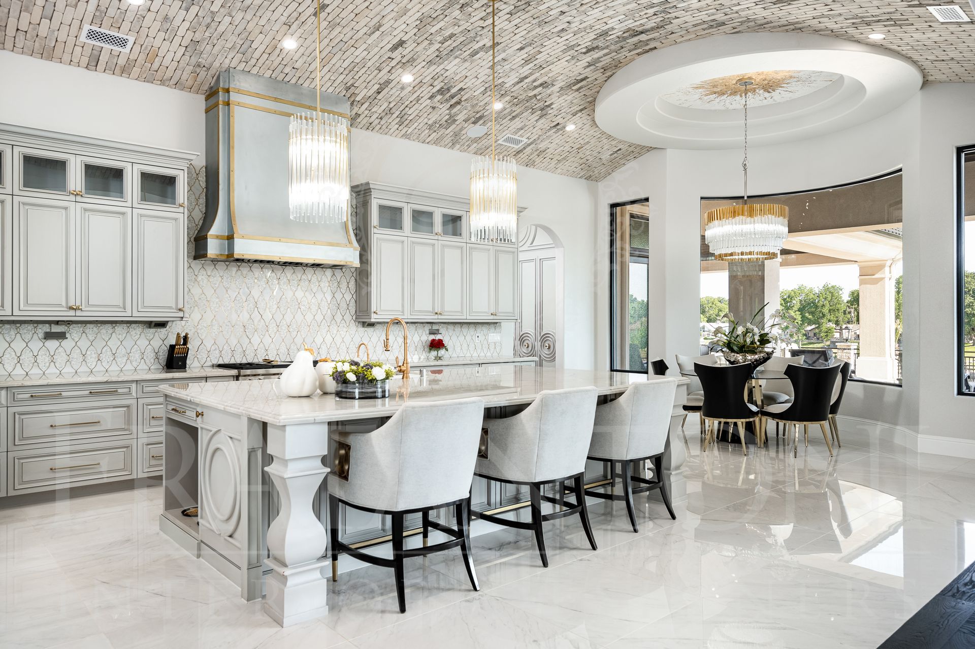 Luxury kitchen with white cabinets, marble island, pendant lights, brick vaulted ceiling, and breakfast nook overlooking backyard designed by fratantoni interior designers in scottsdale arizona