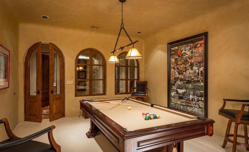 There is a pool table in the middle of the room.