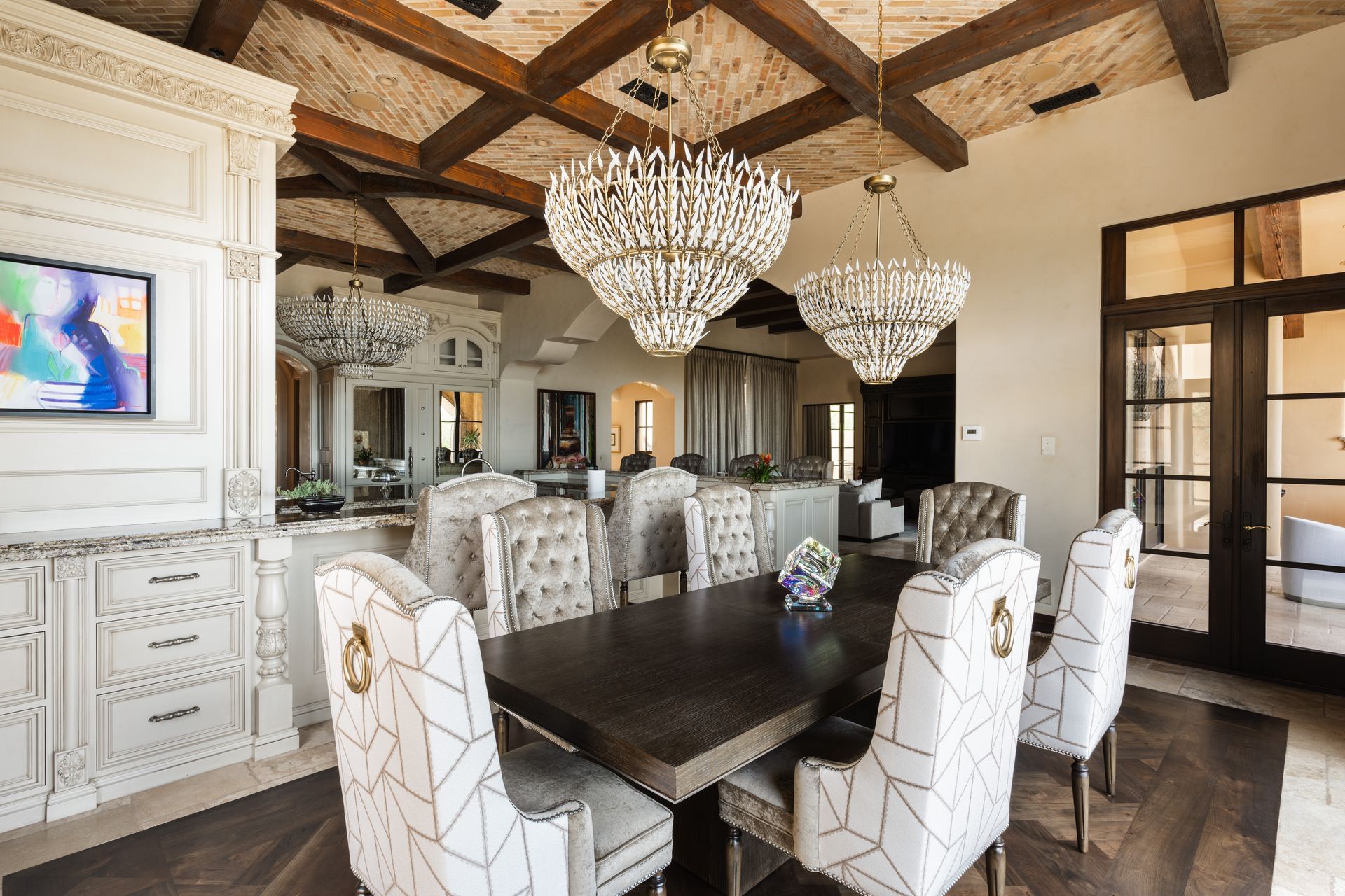 Elegant dining room with chandelier, dark table, patterned chairs, and wood beam ceiling.