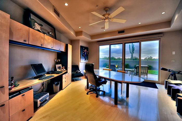 A large room with a table and chairs and a ceiling fan