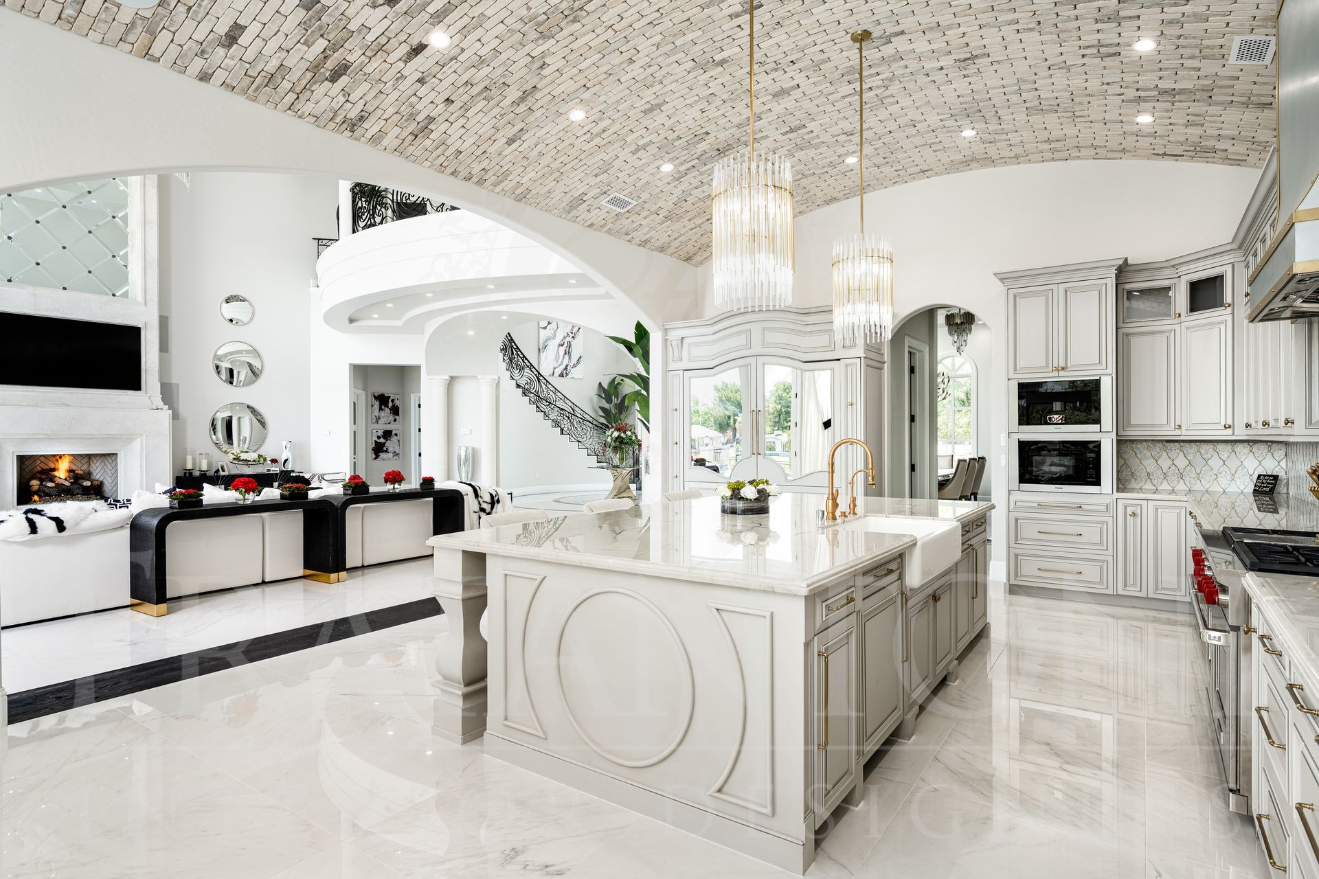 Luxurious white kitchen with marble surfaces and arched brick ceiling overlooking grand living room