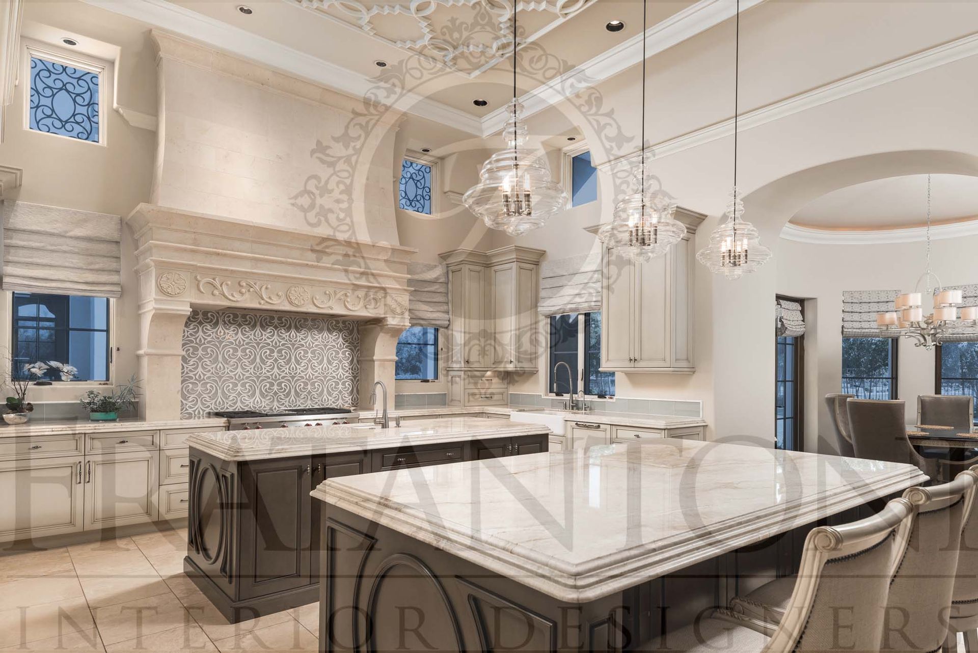 Bright neutral luxury kitchen with marble islands, ornate cabinetry, mosaic stove backsplash under stone range hood, and glass pendant lighting designed by fratantoni interior designers in scottsdale, arizona