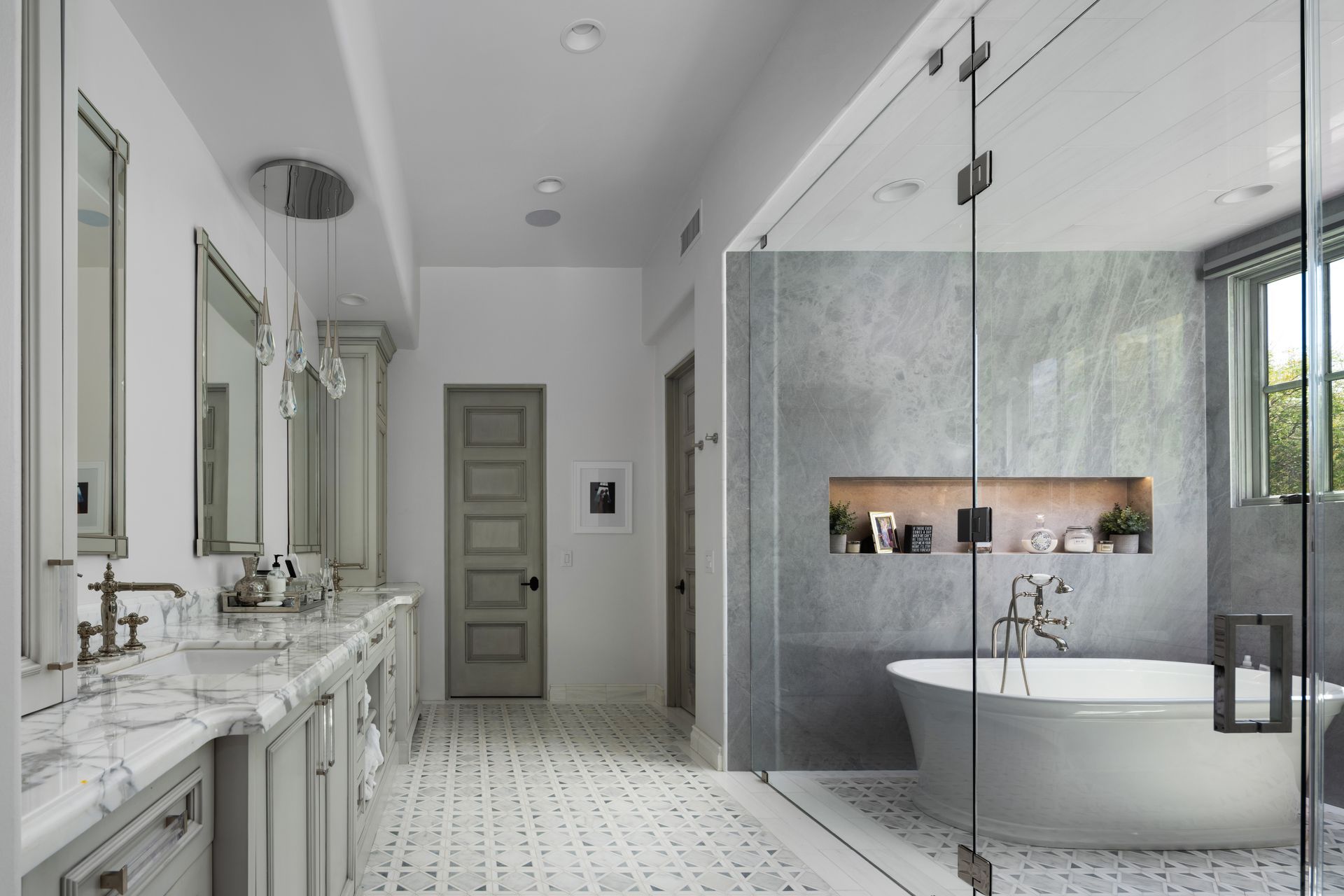 Spacious, bright bathroom with marble countertops, soaking tub, and walk-in shower.
